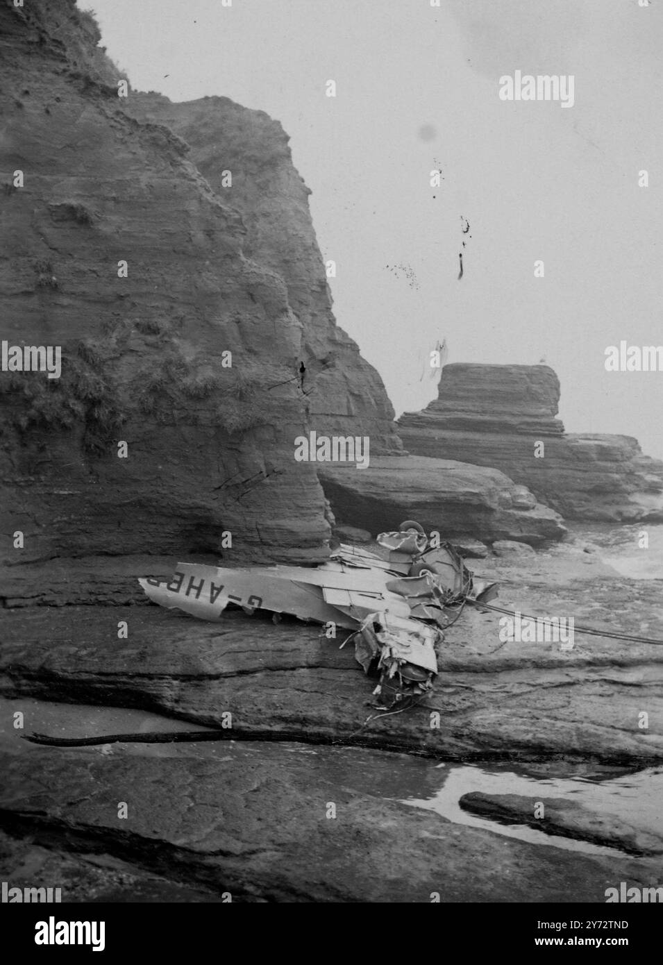 Teil des Wracks eines Privatflugzeugs auf den Felsen von Preston, wo der Pilot, der von Kent nach Cornwall flog, absichtlich ins Meer gestürzt ist, um zu vermeiden, auf Häuser entlang der Promanade in Paignton, Devon, herunterzukommen. Er ist Mr. R.V.D.Beaumont aus London, Sohn der Dame von Sark. Bei ihm waren Mr. Und Mrs. Arindell. Sie wurden alle von Feuerwehrleuten aus dem Meer gerettet und die Polizei ist jetzt im Krankenhaus. 12. November 1946 Stockfoto