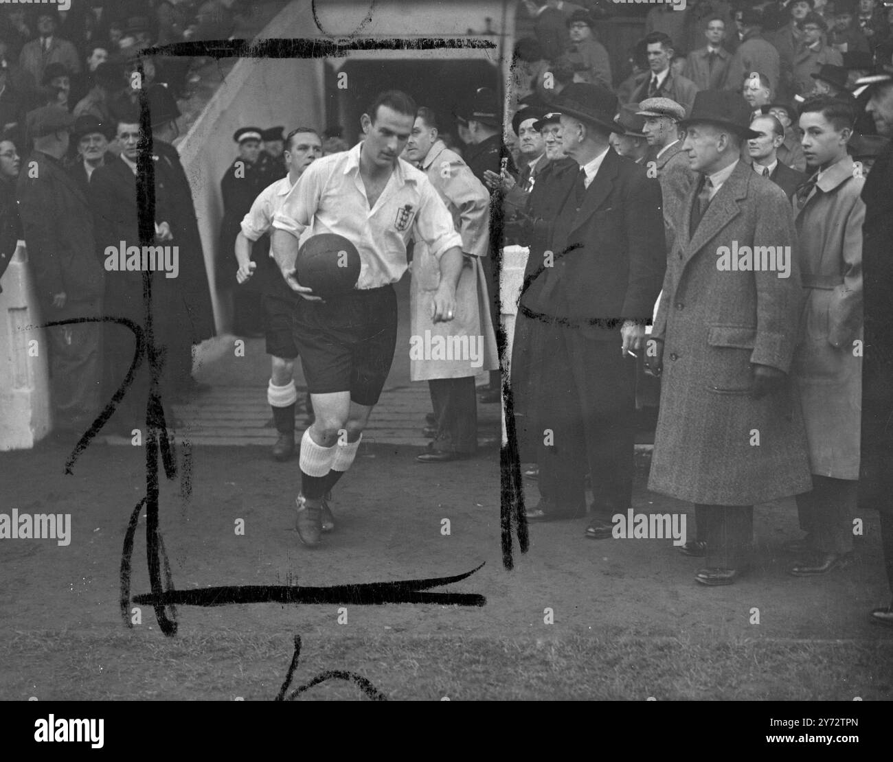 Fast 60.000 Menschen sahen, wie England Wales bei der ersten Fußball-Nationalmannschaft, die acht Jahre lang im Manchester, Maine Road Stadium, gespielt wurde, mit drei Toren besiegte. Das Bild zeigt: Engländer Hardwick tritt mit seinem Team ins Feld ein. 13. November 1946 Stockfoto