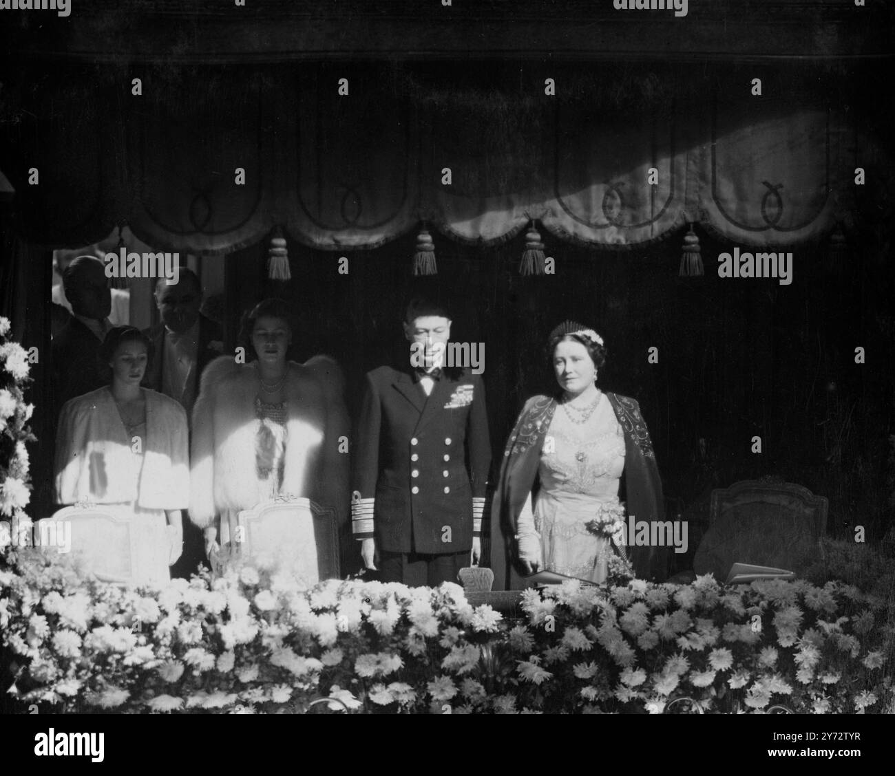 Ihre majesties der König und die Königin, begleitet von Prinzessin Elizabeth und Prinzessin Margaret, besuchten das Palladium Theatre für die Royal Command Variety Performance, die mehr als 200 Künstler auftraten. Das Bild zeigt: Ihre majesties der König und die Königin, Prinzessin Elizabeth und Prinzessin Margaret stehen in der mit Blumen geschmückten Royal Box für die Nationalhymne am Londoner Palladium. 4. November 1946 Stockfoto