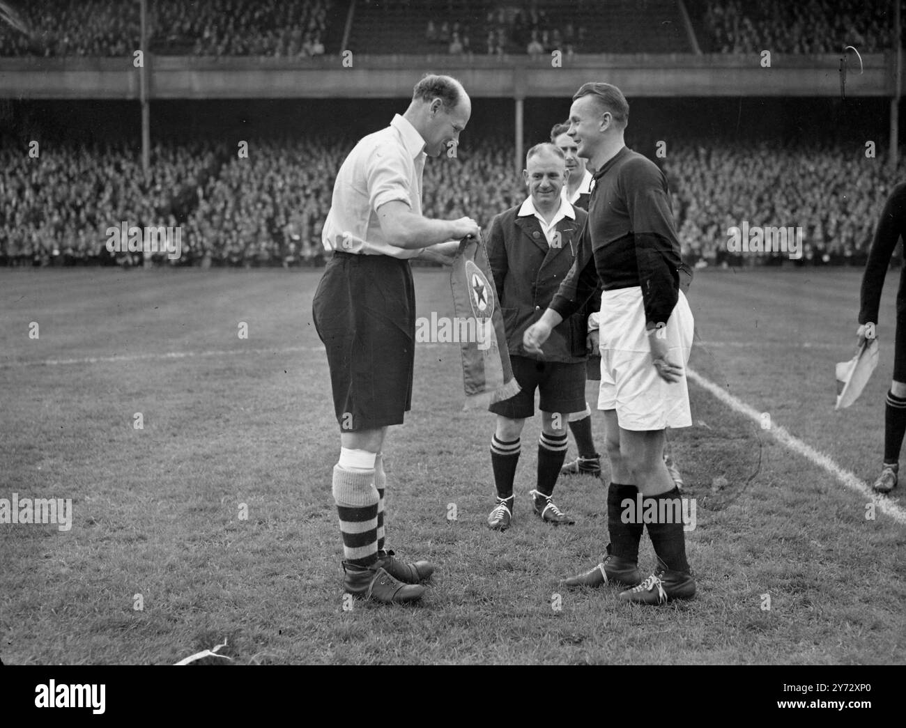 Die tschechoslowakische Fußballmeisterschaft Sparta A. C, eröffnete ihre Tour heute Nachmittag mit einem Spiel gegen das Arsenal in Highbury. Das Bild zeigt: George Zastera, linker Rücken und Kapitän von Sparta, übergibt einen Stab an den Mann, von Arsenal, vor dem Spiel in Highbury heute Nachmittag. 2. Oktober 1946 Stockfoto