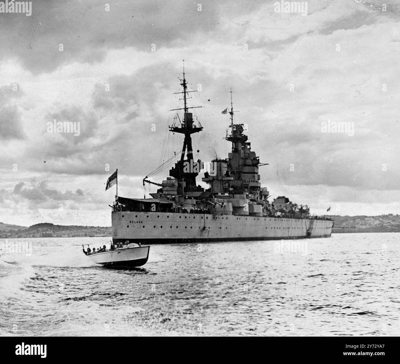 Der Seeheater ist ein Ausbildungs-Flaggschiff. Die 34.000 Tonnen schwere HMS Nelson ist das Flaggschiff der Training Battleship Squadron unter dem Kommando von Konteradmiral H Hickling, DSO, Rear ADML, Training Battleships, Home Fleet. Nachkriegsaufgaben sind die Ausbildung in Seemannschaft, Kanonenschießen und Torpedos für Sonderdienste, die die Hälfte der Marinestärke in Friedenszeiten bilden. Vierhundert Männer gleichzeitig werden in ihr ausgebildet. Fotoshows, HMS Nelson 'Nell to the Royal Navy' vor Anker in Torbay, Devon. 19. September 1946 Stockfoto