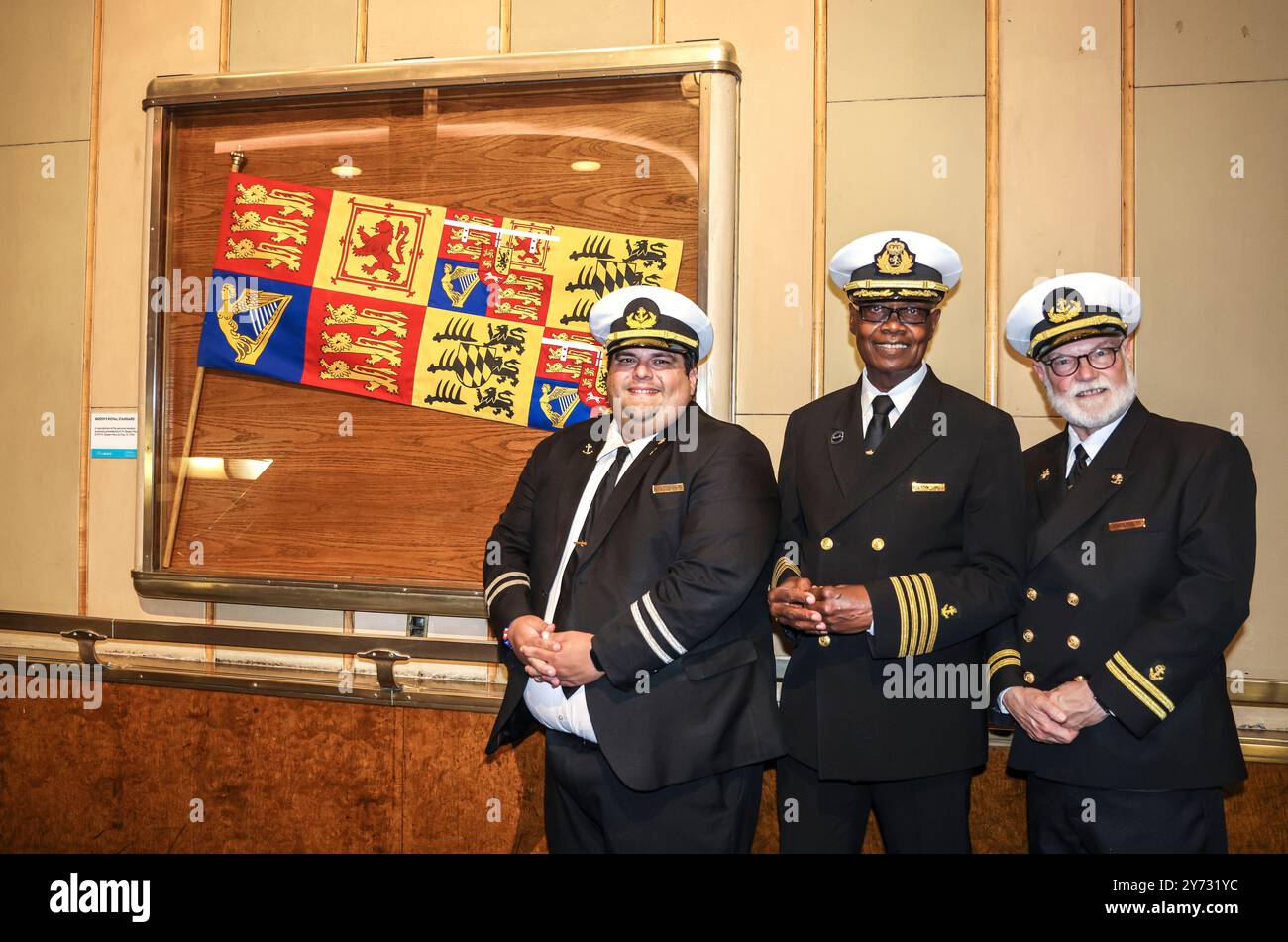 Long Beach, Kalifornien, USA. September 2024. 26. September 2024, Long Beach, Kalifornien, USA: Queen Mary Captain JAMES SANDERS wird von DANIEL RANGEL (links) und PAUL JACEK (rechts) flankiert. Das Schiff feierte sein 90-jähriges Jubiläum mit der Enthüllung eines neuen handgemalten Royal Standard, der den Tag markiert, an dem Cunards Job 534 offiziell Queen Mary genannt wurde. (Kreditbild: © Ron Lyon/ZUMA Press Wire) NUR REDAKTIONELLE VERWENDUNG! Nicht für kommerzielle ZWECKE! Stockfoto