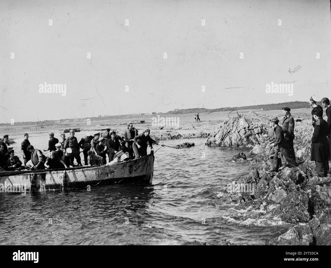 1500 Männer der britischen Marine waren Passagiere aus Australien an Bord des amerikanischen Schiffes Georgetown Victory, das auf den Felsen am Killard Point, Strangford, südlich von Belfast fuhr. Alle Passagiere und die Besatzung wurden gerettet, aber das Schiff war hoffnungslos in den Felsen eingeklemmt, ihr Rücken gebrochen und ihr Deck aufgebrochen. Fotoshows Überlebende des Georgetown Victory kommen in einem Rettungsboot an Land und bringen ihr persönliches Eigentum mit, das sie aus dem Wrack retten könnten. 2. Mai 1946 Stockfoto