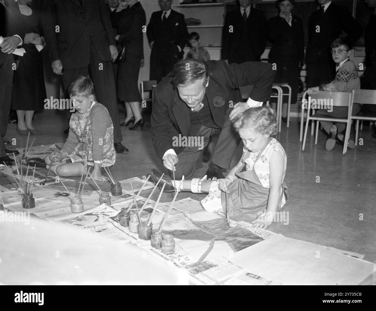 Sir Edward Boyle , Parlamentarischer Sekretär des Bildungsministeriums , spricht mit Lynda Williamson im Alter von 7 Jahren und Ian Fairhead im Alter von 9 Jahren in der Malklasse der New Franklin Delano Roosevelt School für körperlich behinderte Kinder , die Sir Edward gerade offiziell in Hampstead eröffnet hat . 3. Oktober 1957 Stockfoto