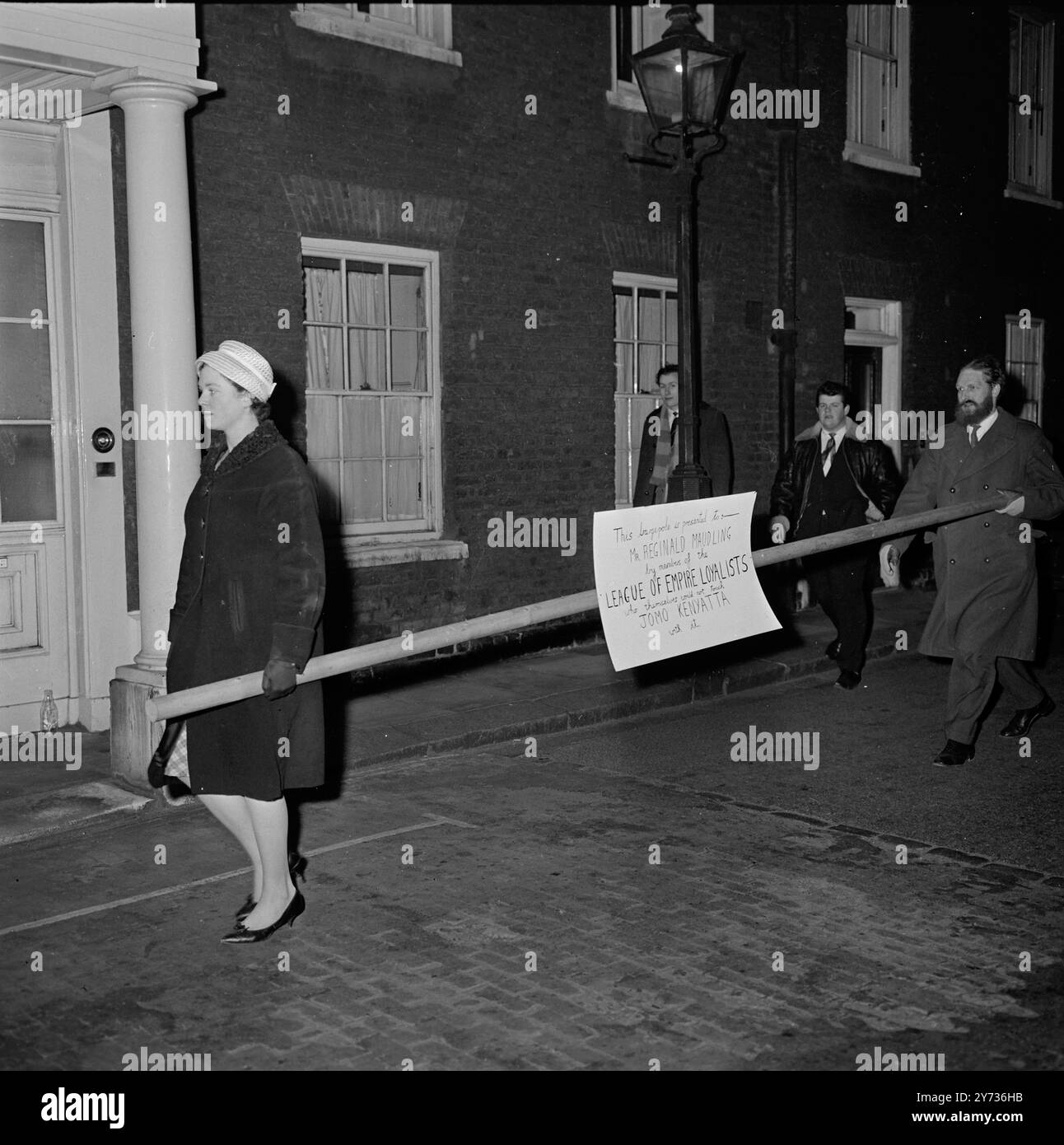 Barge Pol für Maudling. London , Mitglieder der Liga der Empire-Loyalisten , die heute Abend in Lancaster House in London ankommen , mit einem 12 Fuß langen Kahnenmast , an dem ein Plakat mit der Botschaft angebracht ist , " dieser Kahnenmast wird Herrn Reginald Maudling von Mitgliedern der Liga der Empire-Loyalisten überreicht , die selbst Jomo Kenyatta nicht damit berühren würden " . Die Empire-Loyalisten versuchten, den Pfosten in das Gebäude zu bringen, wurden aber von der Polizei abgewiesen. Lancaster House ist der Veranstaltungsort der Kenia Constitutional Conference , die letzte Woche in London von Herrn Maudling, Großbritannien, eröffnet wurde Stockfoto