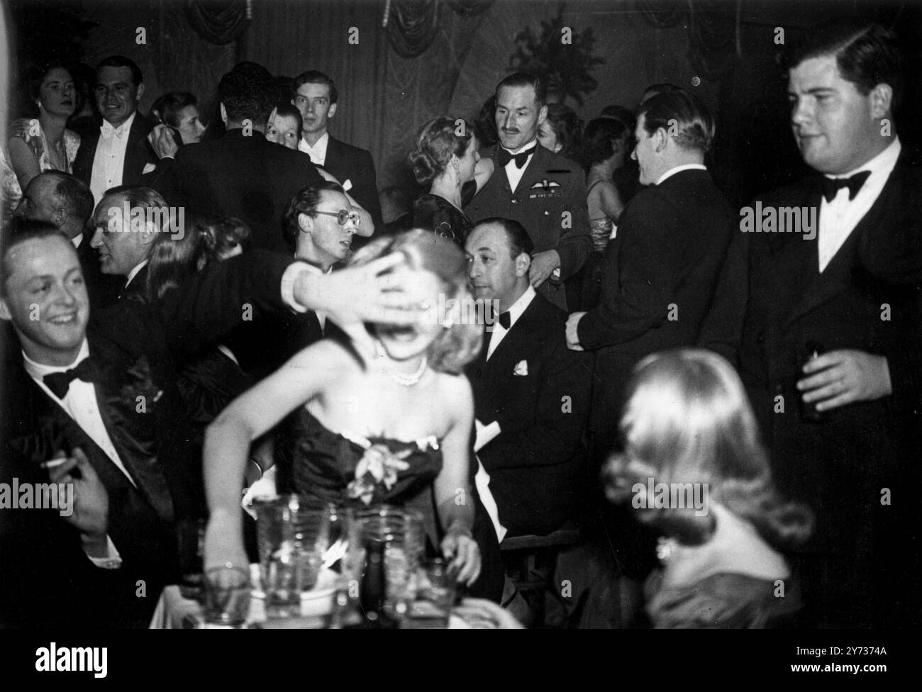 Die Tochter des US-Botschafters geht auf eine Party. Miss Sharman Douglas, Tochter des US-Botschafters, in London, stahlen das Rampenlicht aus der Show, als sie kürzlich den Orchid Room in Mayfair (London) besuchte. Fotoshows, die Miss Sharman Douglas vor dem Kameramann verstecken, sind der Marquess of Blandford, Sohn des Duke of Marlborough. 16. April 1948 Stockfoto