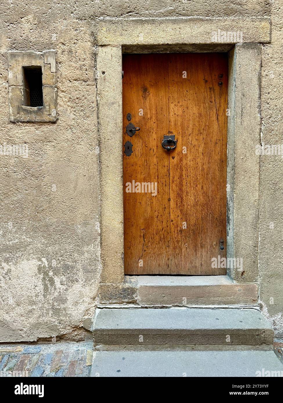 Das Foto zeigt einen detaillierten Blick auf ein altes mittelalterliches Tor aus Holz und Metall in den Straßen einer historischen europäischen Stadt. - Smartphone-aufgenommenes Stockfoto