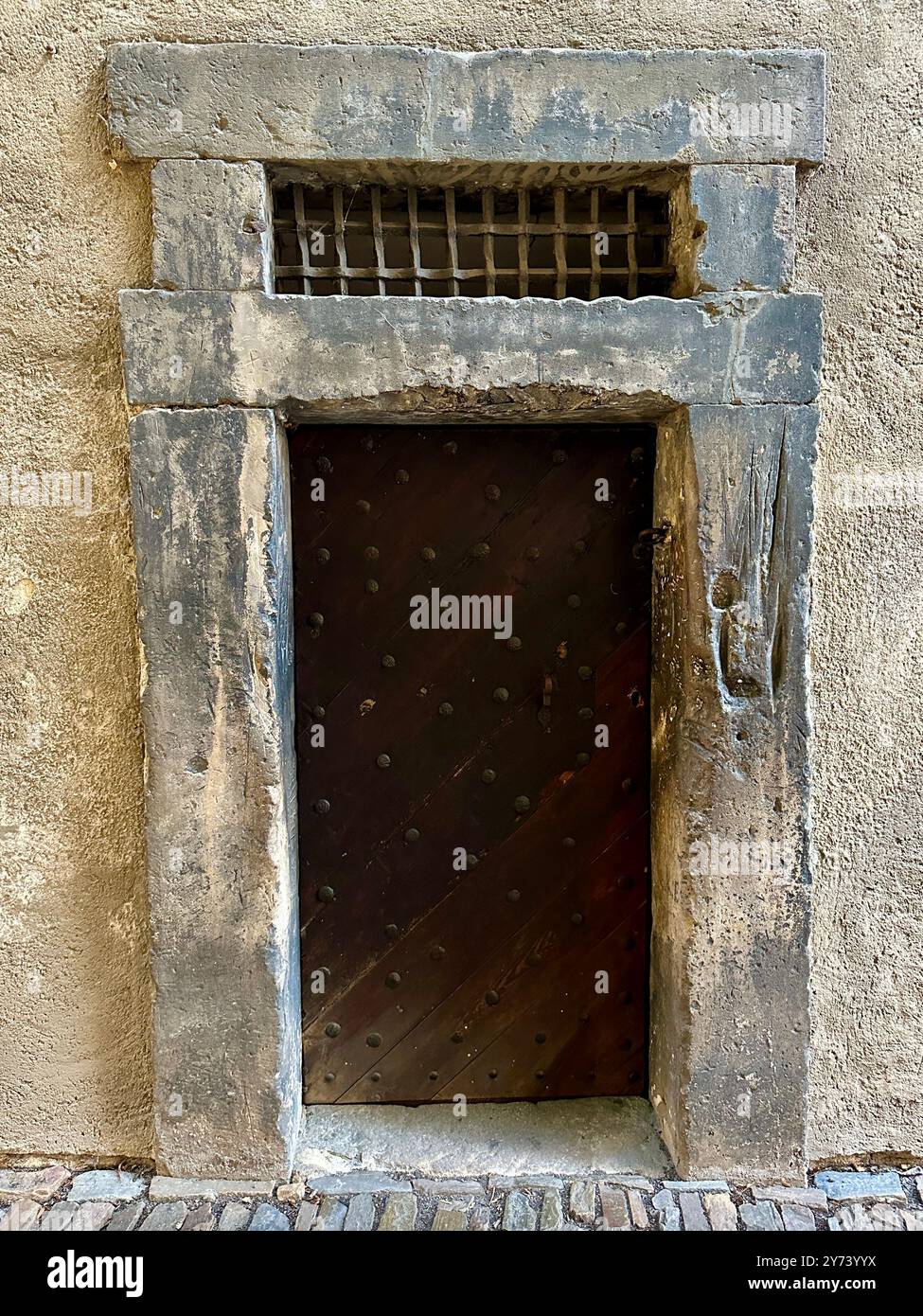 Das Foto zeigt einen detaillierten Blick auf ein altes mittelalterliches Tor aus Holz und Metall in den Straßen einer historischen europäischen Stadt. - Smartphone-aufgenommenes Stockfoto