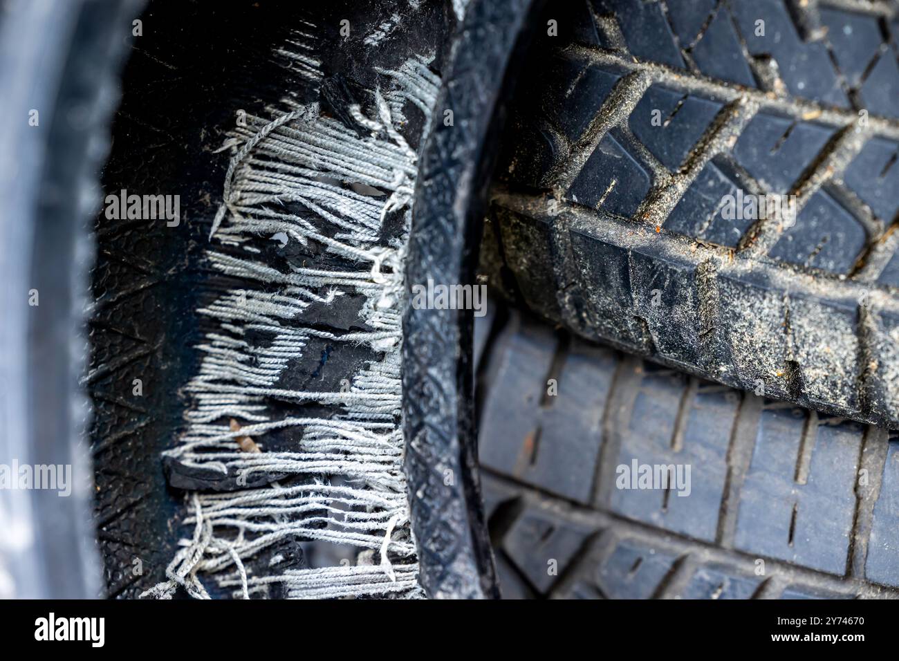 Ein alter, ausgebrannter Autoreifen auf einer Mülldeponie. Alte Reifen verschmutzen die Umwelt Stockfoto