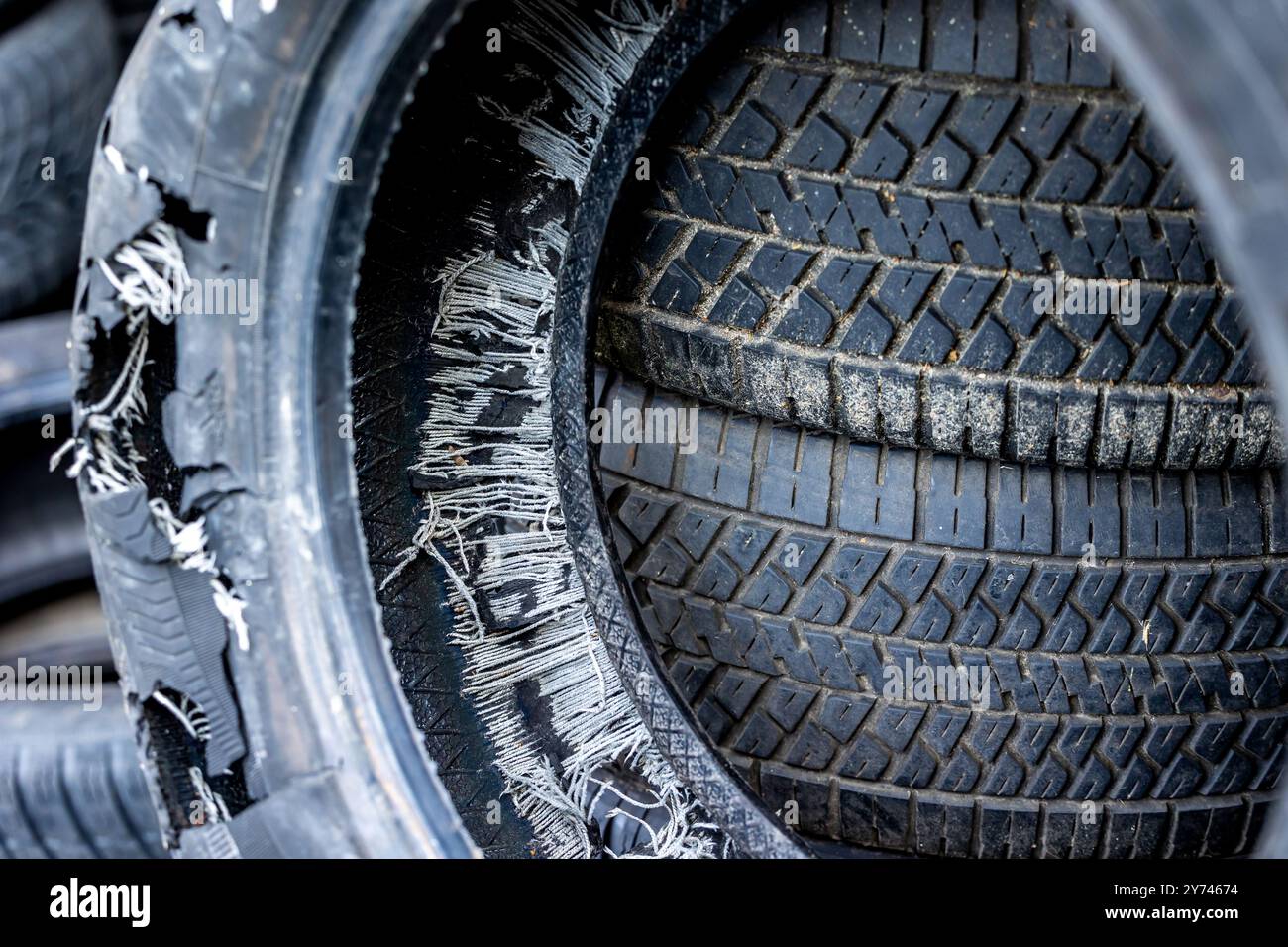 Ein alter, ausgebrannter Autoreifen auf einer Mülldeponie. Alte Reifen verschmutzen die Umwelt Stockfoto