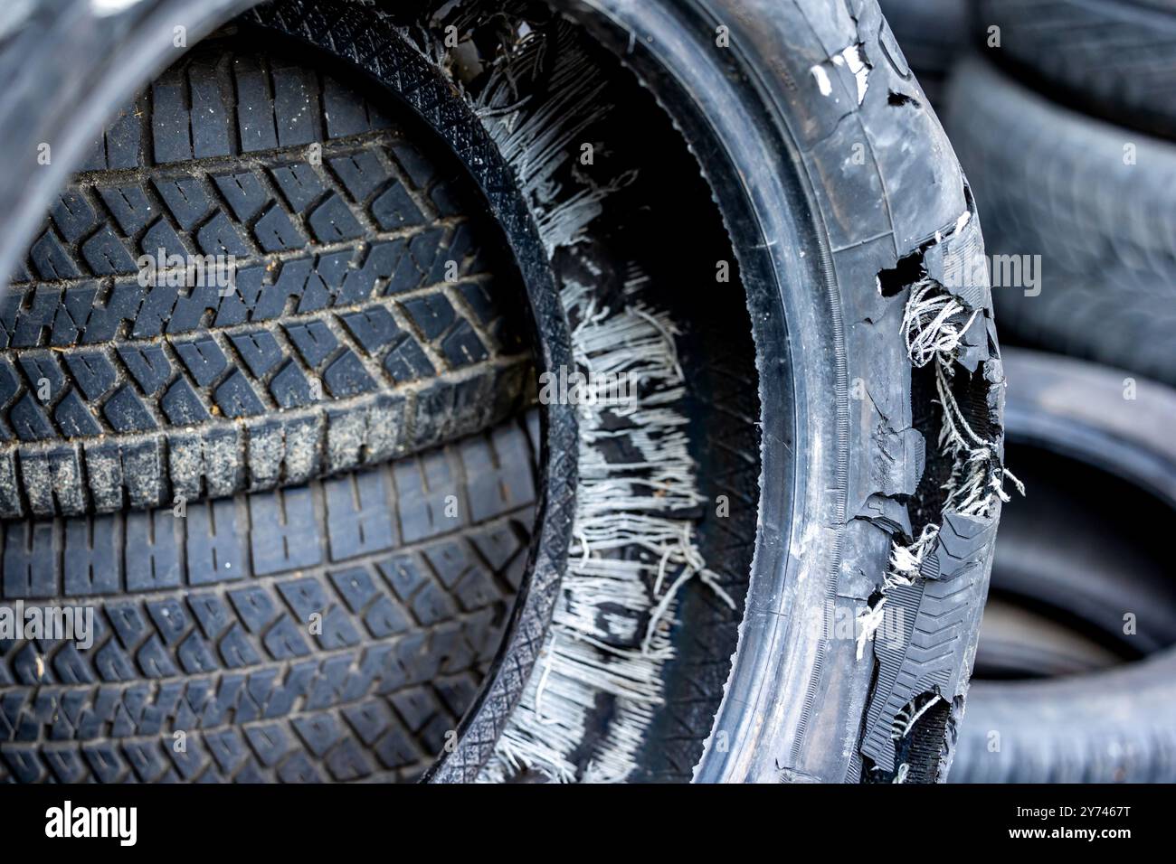 Ein alter, ausgebrannter Autoreifen auf einer Mülldeponie. Alte Reifen verschmutzen die Umwelt Stockfoto