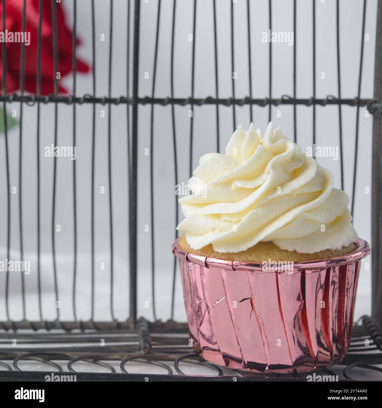 Rosafarbene Cupcakes mit hohem Buttercremewirl, Cupcakes in rosafarbenen Folieneinlagen mit Vanille-Buttercreme, mattierte Cupcakes auf weißem Hintergrund Stockfoto