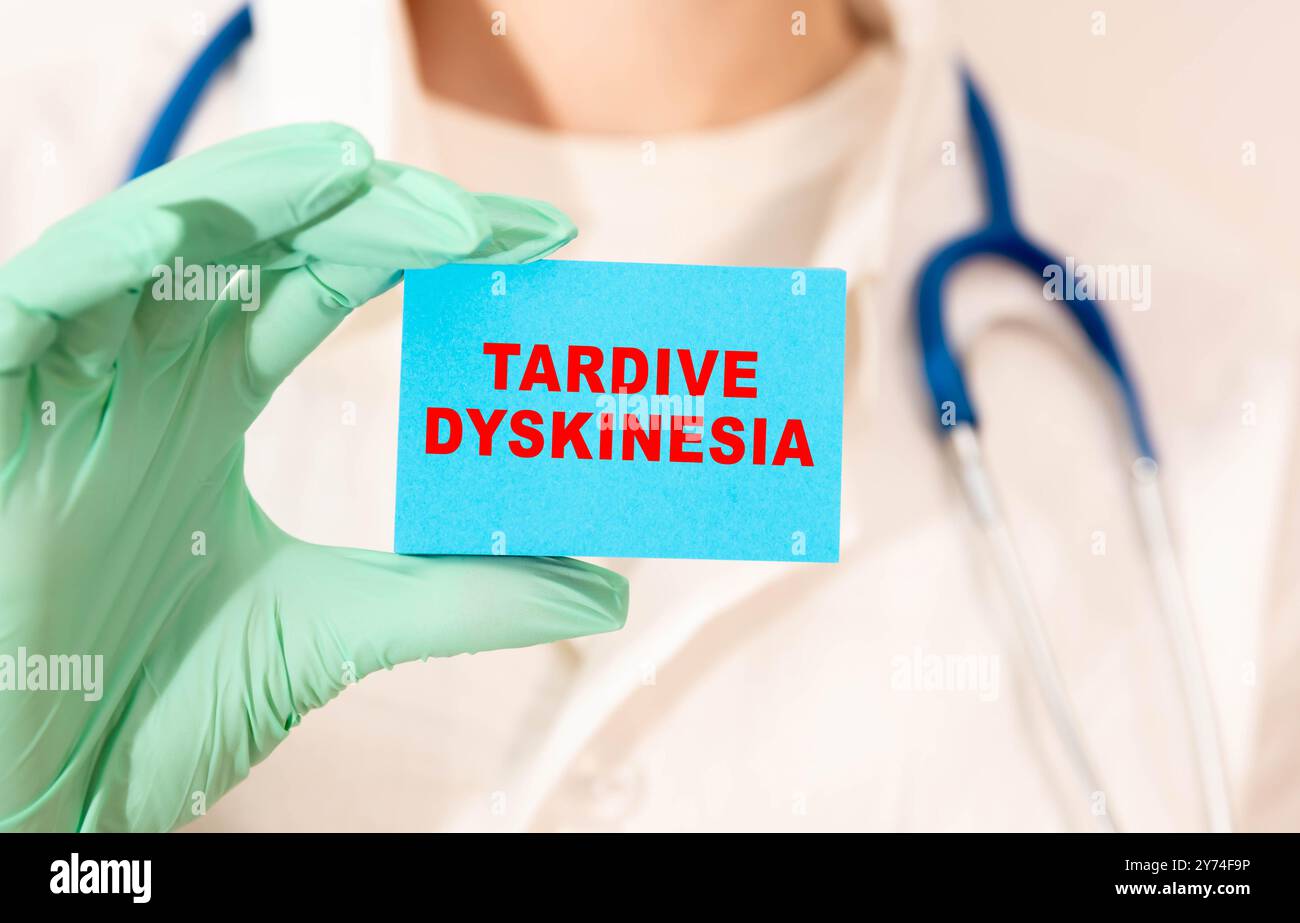 Medizin und Gesundheitskonzept. Auf der schwarzen Oberfläche liegen blaues Papier, ein Stift und ein Notizbuch mit der Aufschrift - Tardive Dyskinesia. Stockfoto