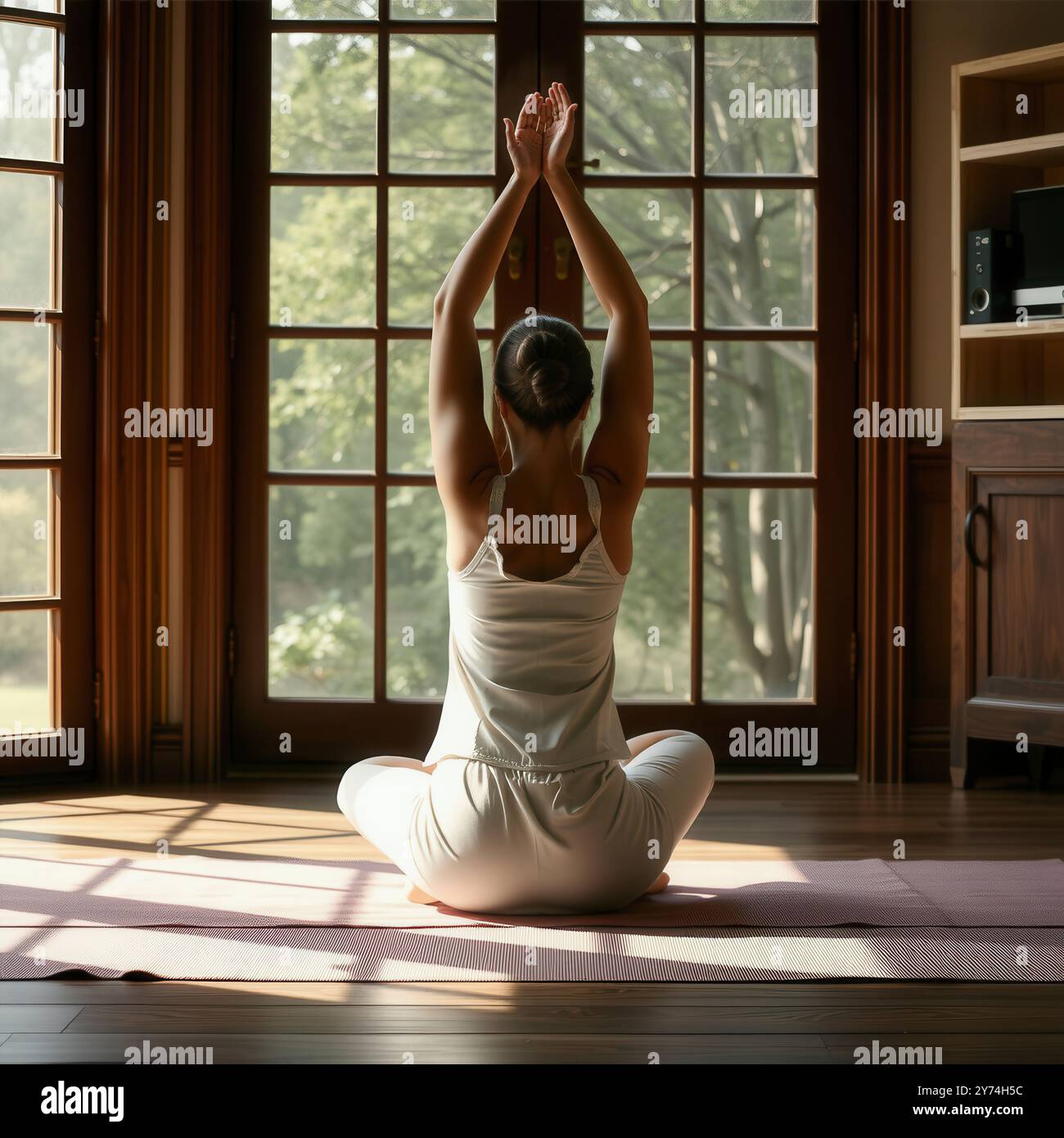 Schöne junge Frau in sitzender Yoga-Pose oder Meditation zu Hause Stockfoto