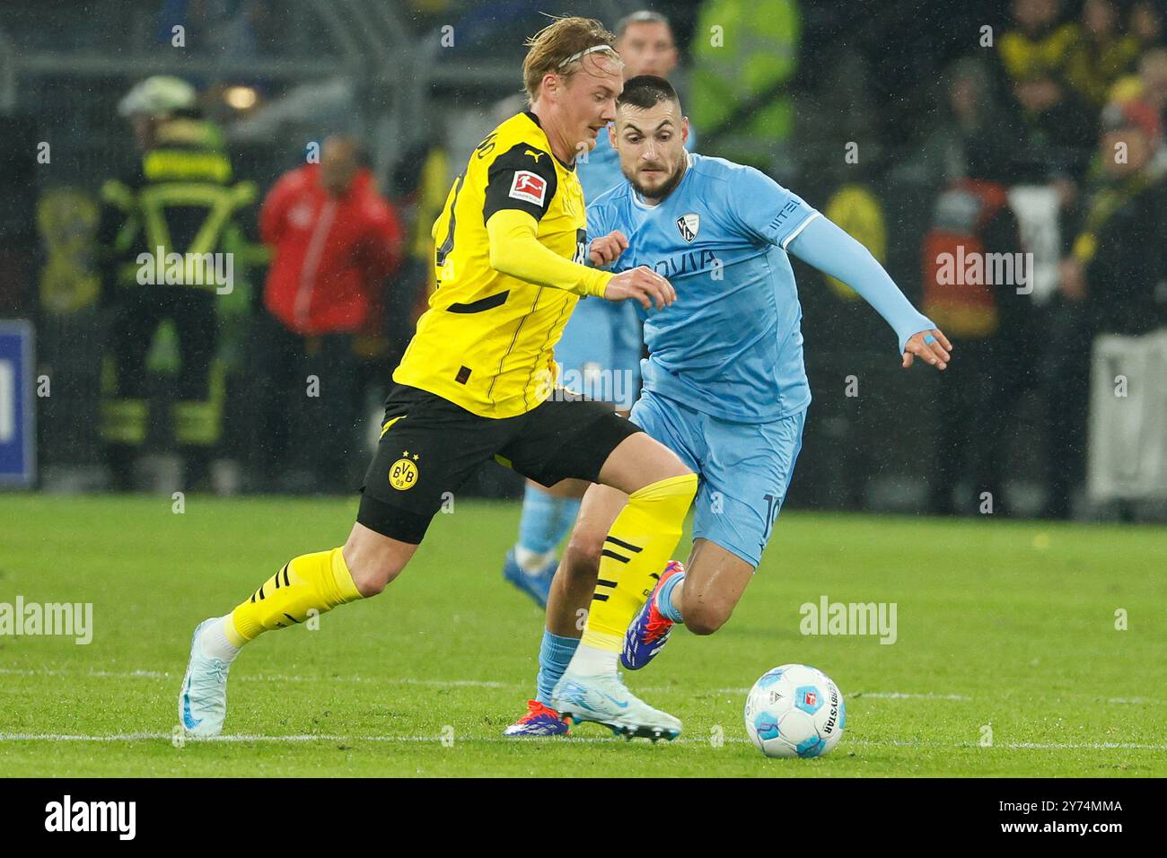 Dortmund, Deutschland. September 2024. Julian Brandt (L) von Borussia Dortmund streitet mit Matus Bero vom VfL Bochum während des ersten Liga-Fußballspiels zwischen Borussia Dortmund und VfL Bochum in Dortmund, 27. September 2024. Quelle: Joachim Bywaletz/Xinhua/Alamy Live News Stockfoto