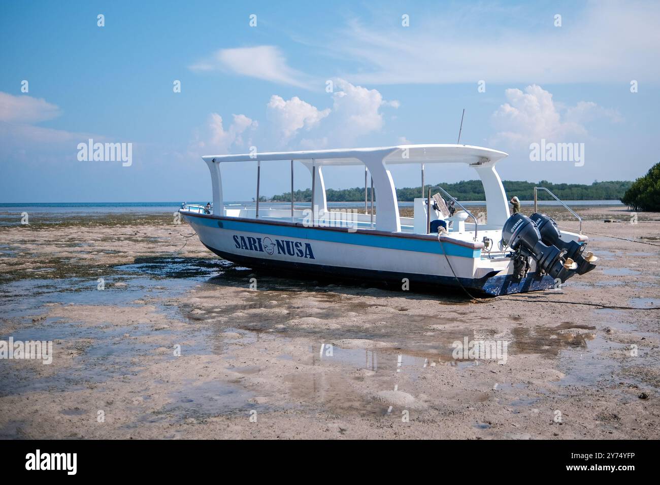 Das Boot ruht am Strand bei Ebbe an einem sonnigen Tag Stockfoto
