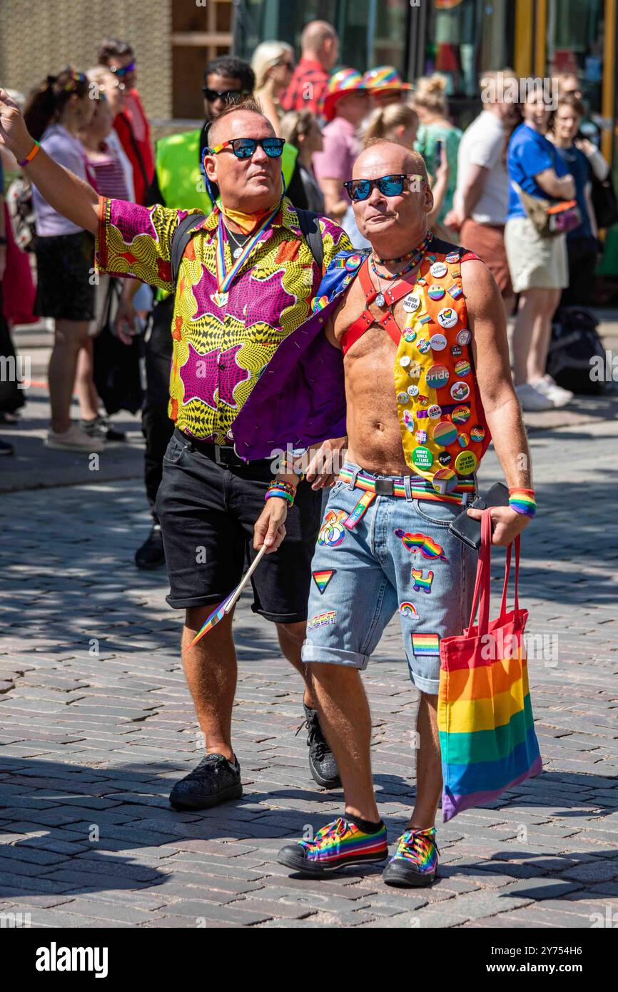 Männliches Paar in Sommerkleidung bei der Helsinki Pride 2024 Parade auf der Mannerheimintie in Helsinki, Finnland Stockfoto