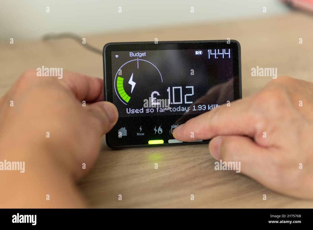 Eine Person, die den Energieverbrauch auf einem intelligenten Zähler zu Hause überprüft. Ein Konzept der Technologienutzung. Stockfoto