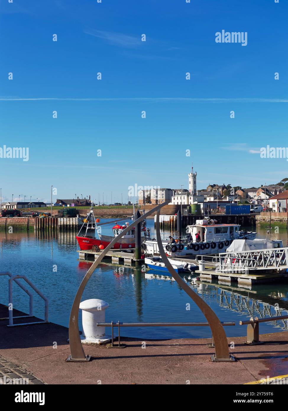 ArbroathÕs Tidal Harbour mit Blick auf den Outer Harbour Pontoon und Gehweg mit Fischern, die an Bord des Ultimate Predator Fischerschiffs gehen. Stockfoto