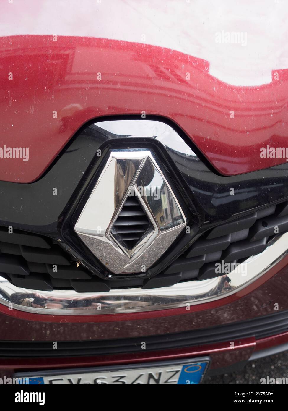 Cremona, Italien 26. September 2024 Nahaufnahme eines renault-Logos auf der Vorderseite eines roten Autos, mit der Reflexion der Straße in Chrom Stockfoto