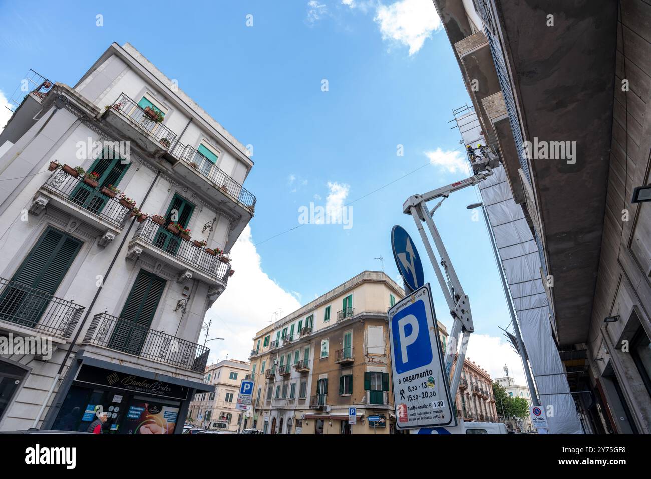 Messina, Italien – 21. Mai 2024: Messinas klassische Straßen werden in Pflege gehalten. Arbeiter auf einem Kran hauchen einem alten Gebäude neues Leben ein, während die Stadt s Stockfoto