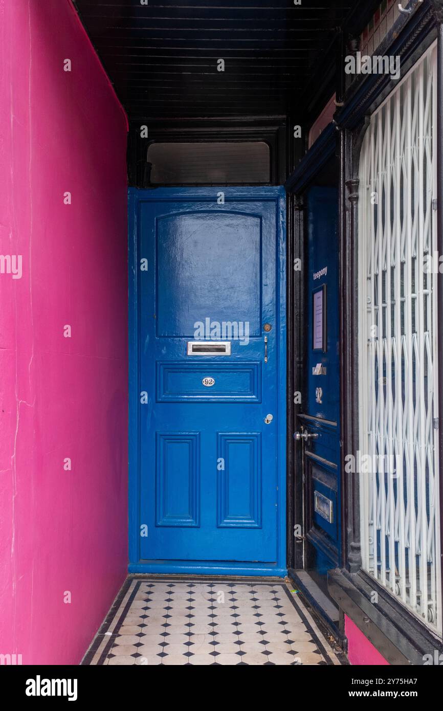 Blaue Tür und eine rote magentafarbene Wand, Brighton, Großbritannien (September 24) Stockfoto