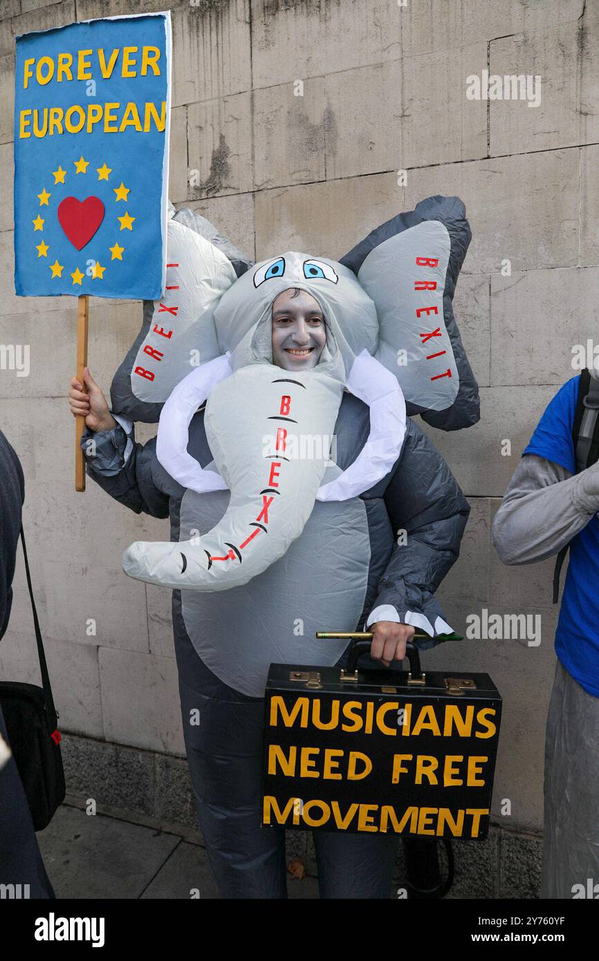 London, Großbritannien, 28. September 2024. Ein Mann, der als Elefant gekleidet ist, hält ein Protestzeichen hoch. Tausende nehmen an dem dritten National Rejoin March in Central London Teil. Demonstranten rufen Großbritannien dazu auf, wieder der Europäischen Union beizutreten, nachdem das Land im Referendum 2016 für den Austritt gestimmt hat. Quelle: James Willoughby/Alamy Live News Stockfoto