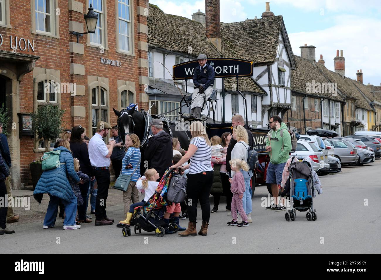 Lacock;, Großbritannien. September 2024. Traditionelle Bierlieferung. Das Red Lion Inn in Lacock hat heute einige besondere Besucher. Die Wadworth Brewery liefert Bier auf traditionelle Weise in die Pubs in der Nähe der Brauerei, mit einem Wagen oder einer Dray, der von einem prächtigen Pferd gezogen wird, aber manchmal nimmt das Team mit dem LKW einen Besuch in ihren Lieblings-Pubs in Wiltshire. Unberührtes Lacock Village ist ein beliebtes Filmset, das in den Filmen Downton Abbey und Harry Potter zu sehen war. Quelle: Mr Standfast/Alamy Live News Stockfoto