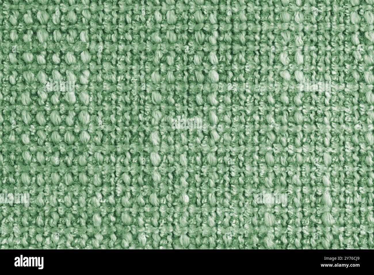 Textur des grünen Jacquard-Gewebes aus rauem Gewebe, Stoffstrukturhintergrund, Nahaufnahme, Makro. Material für Heimtextilien, Polster und Vorhangdekor, Stockfoto