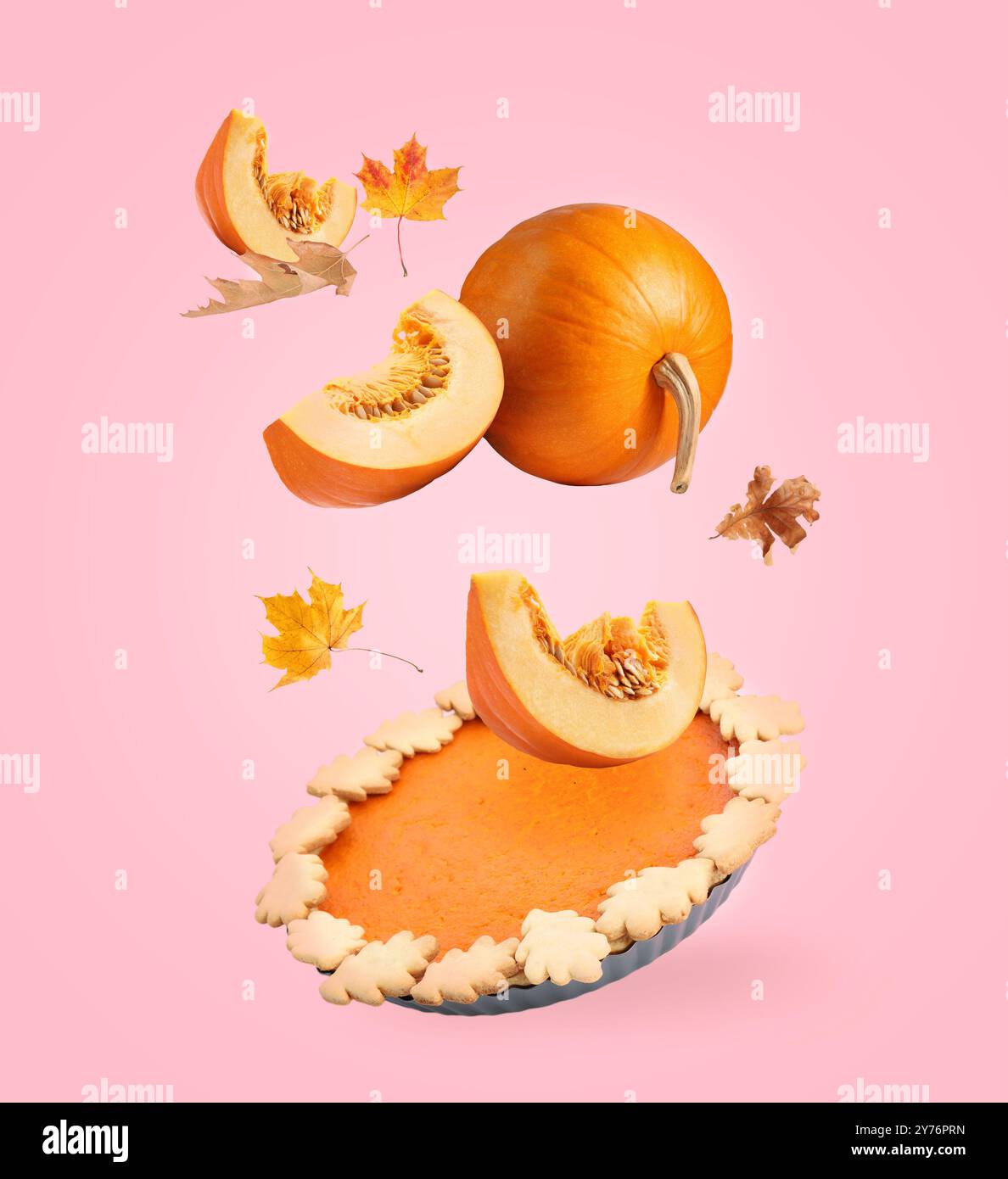 Herbstkuchen, Kürbisse und Orangenblätter in der Luft auf rosa Hintergrund Stockfoto