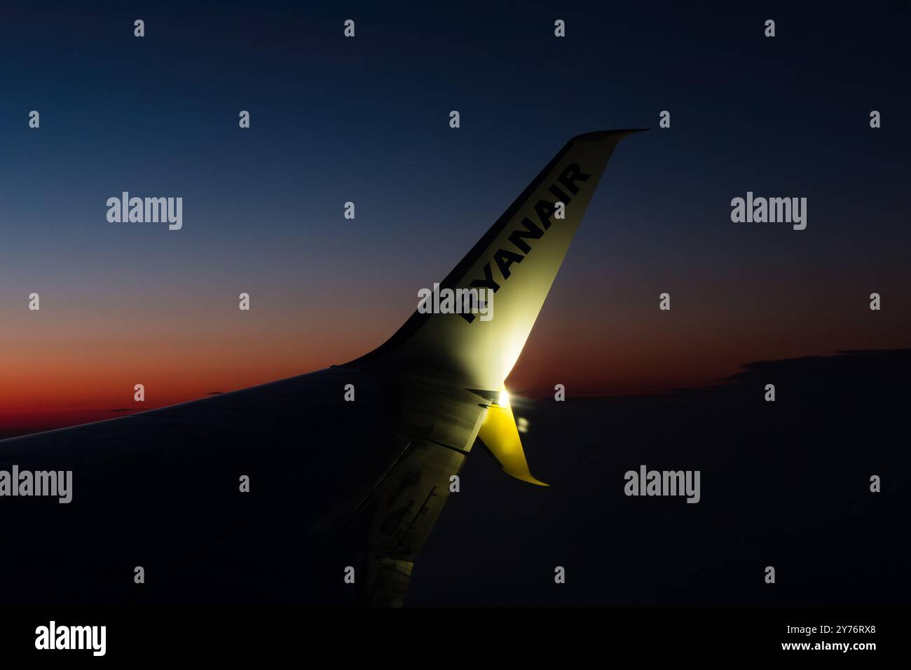 London, Großbritannien - 21. Juli 2024: Ryanair-Flugzeuge fliegen bei Sonnenuntergang. Flugzeugflügel mit Ryanair-Logo. Stockfoto