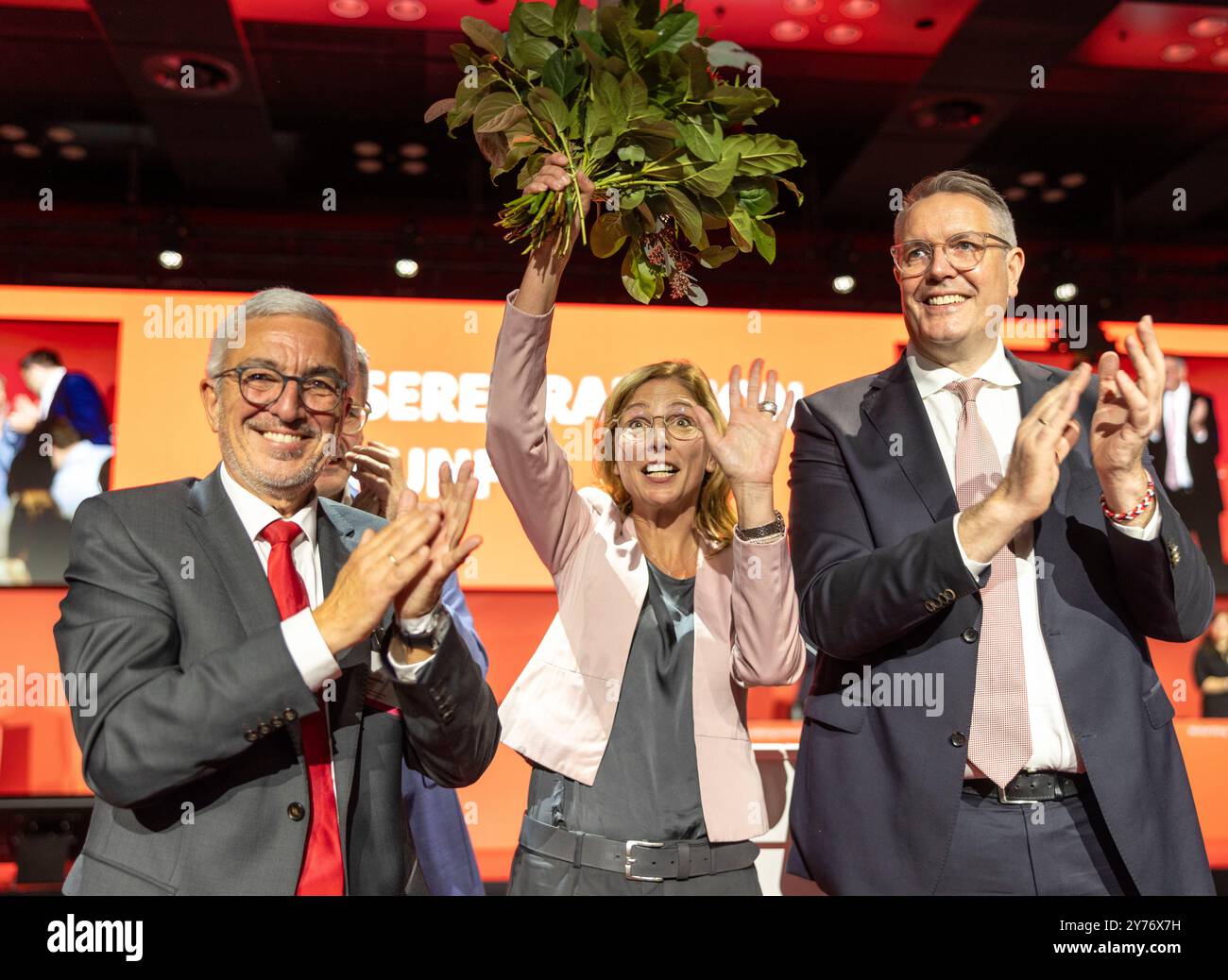 Mainz, Deutschland. September 2024. Der scheidende Rheinland-pfälzische SPD-Chef Roger Lewentz (l) und Alexander Schweitzer (SPD, r), Ministerpräsident Rheinland-Pfälziens, klatschen bei der außerordentlichen Parteikonferenz der Rheinland-pfälzischen SPD neben der neu gewählten Parteivorsitzenden Sabine Bätzing-Lichtenthäler. Die Rheinland-pfälzische SPD wählte auf der Parteikonferenz auch ihren Fraktionsvorsitzenden zum Parteivorsitzenden mit großer Mehrheit. Quelle: Helmut Fricke/dpa/Alamy Live News Stockfoto