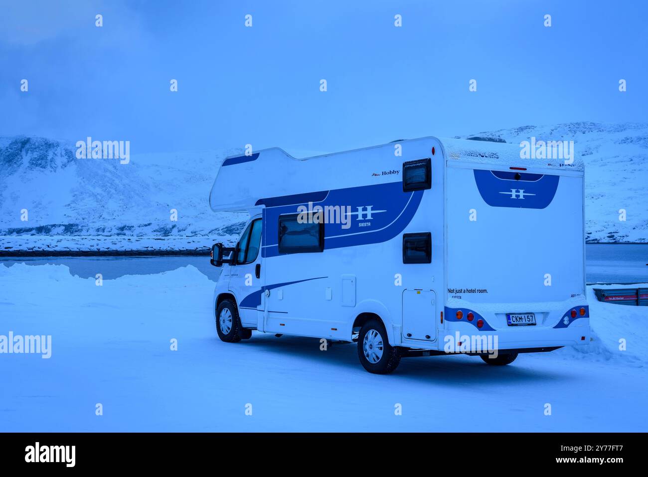 Ein Wohnmobil im Dorf Skarsvåg, Gemeinde Nordkapp, während einer blauen Stunde an einem schneebedeckten Wintertag (Nordkapp, Finnmark, Norwegen) Stockfoto