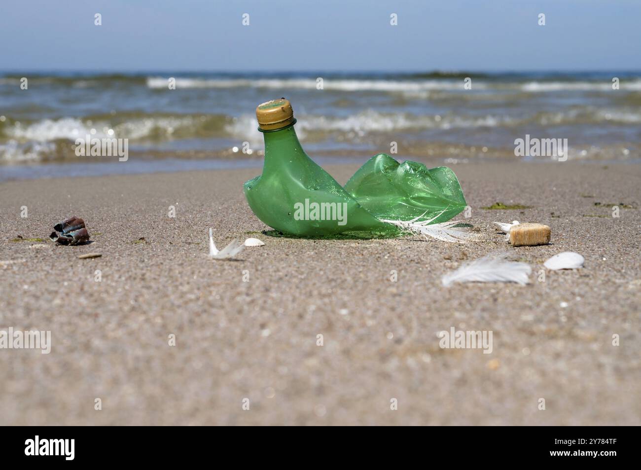 Die Verschmutzung der Küste mit Plastikflaschen. Müll am Strand. Plastik am Strand. Grüne leere Flasche Stockfoto