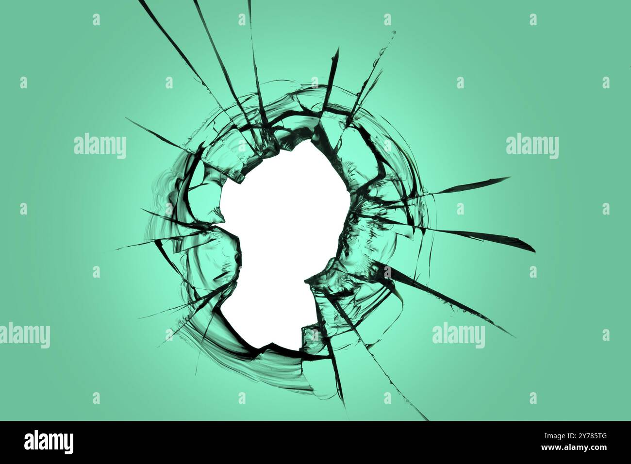 Ein Loch in grünem Glas. Zerbrochenes Fenster mit Rissen in der Struktur, Effekt für Konstruktionslösungen Stockfoto