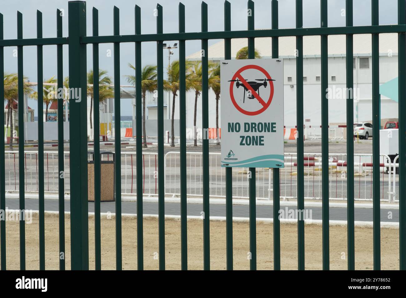 Poster mit der Silhouette der Drohne im gekreuzten roten Kreis und Text No Drone Zone am grünen Zaun in Oranjestad, Aruba. Stockfoto