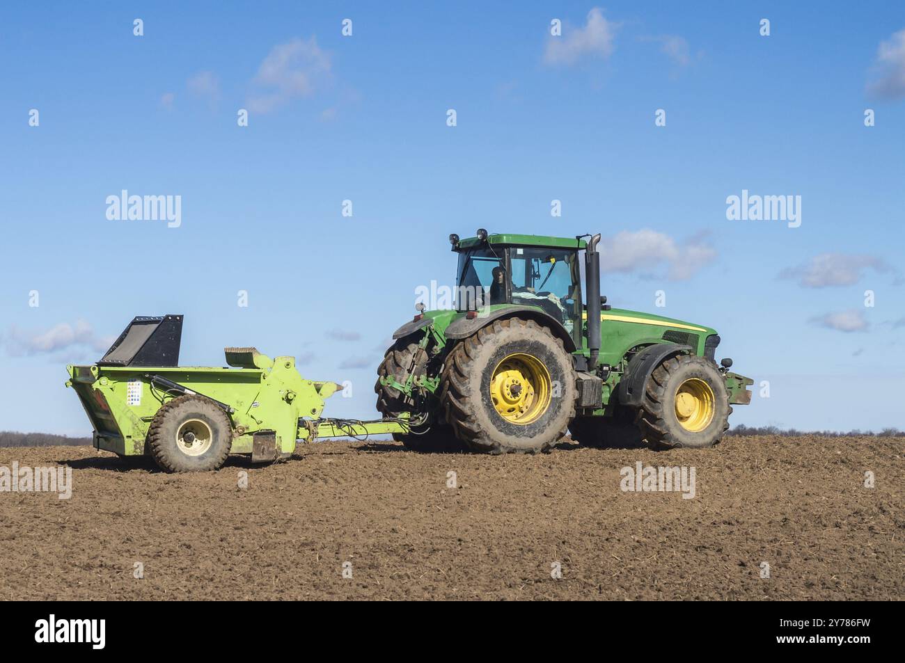 Kaliningrad, Russland, 2021, 4. April: Frühjahrspflügen. Landwirtschaftliche Arbeit auf dem Feld. Ein Traktor, der das Land pflügt. Bodendüngung, Europa Stockfoto