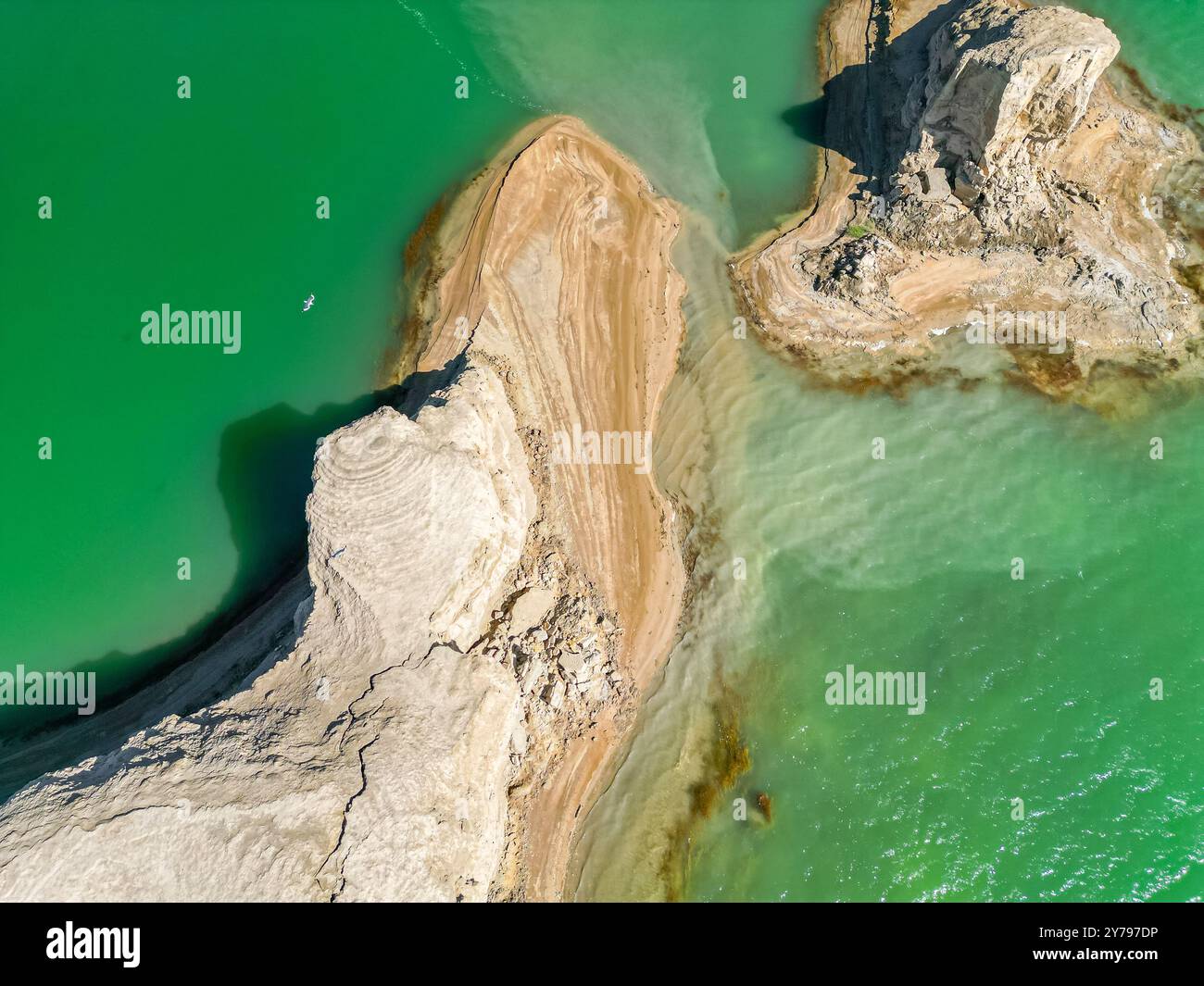 Ein malerischer Blick auf den Wusute Yadan Geopark mit kleinen Felsformationen auf dem Wasser in Qinghai, China, Luftbild im Hintergrund, Vögel fliegen über die Landformen Stockfoto