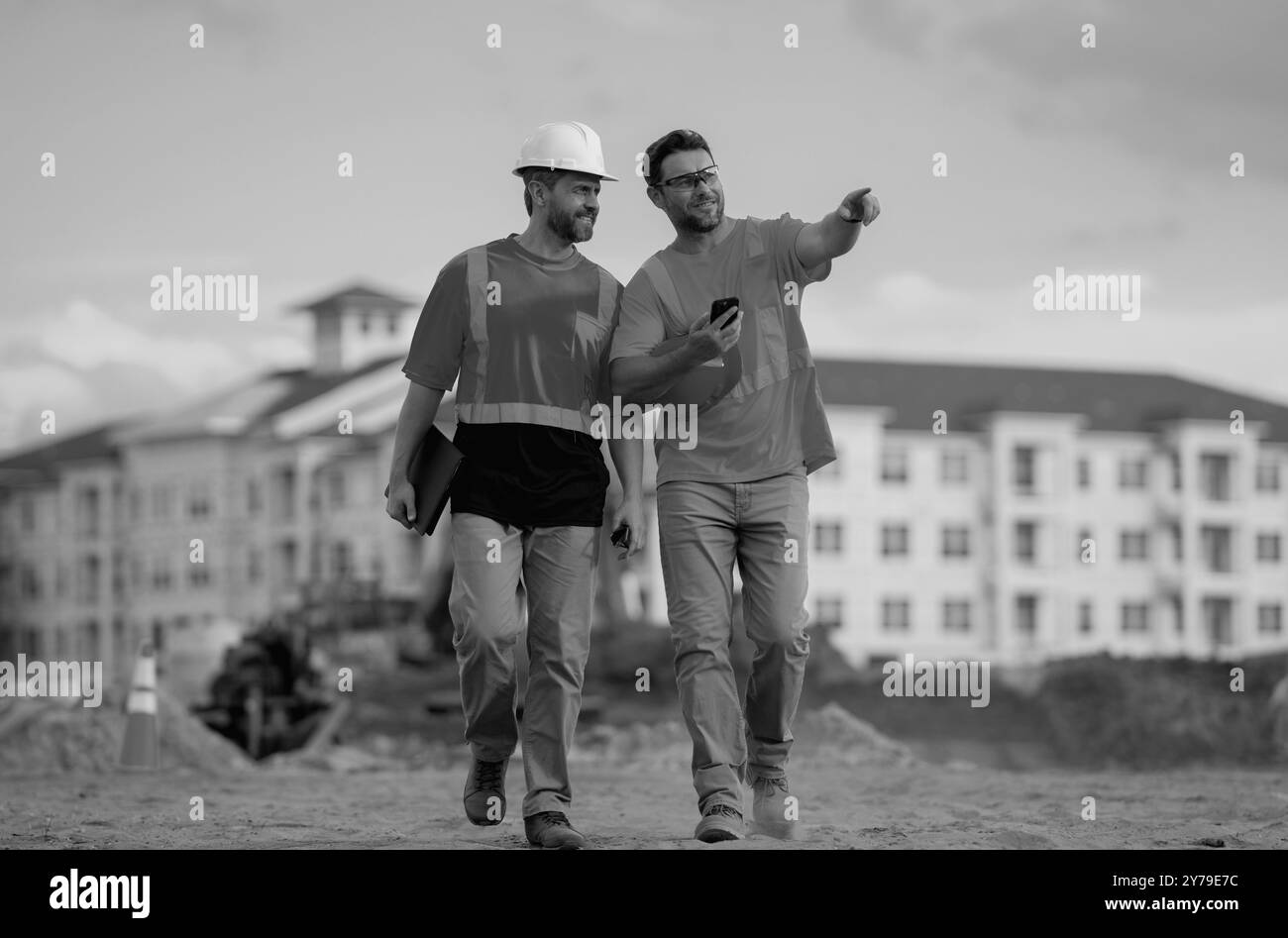 Zwei Bauarbeiter in einem Helm im Gebäude. Baugebäude. Baustellenleiter. Helmarbeiter im neuen Gebäude. Zwei Baumeister Stockfoto