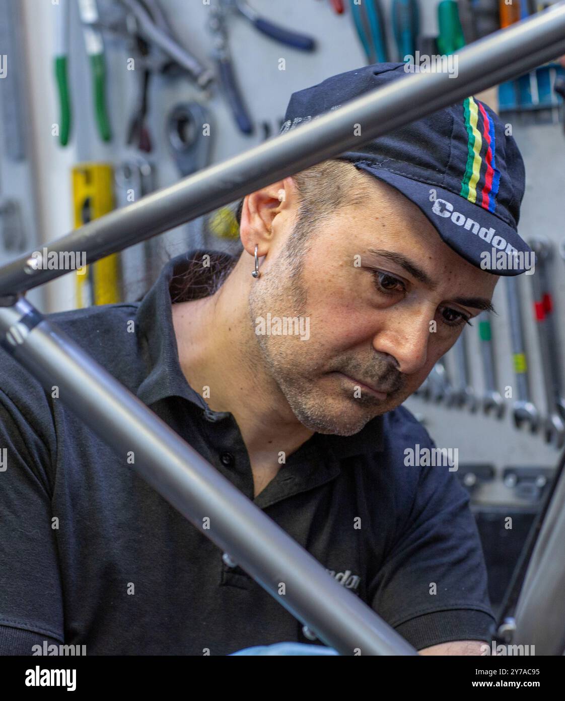 Männlicher Fahrradmechaniker in einer Werkstatt repariert ein Fahrrad, London, Großbritannien Stockfoto