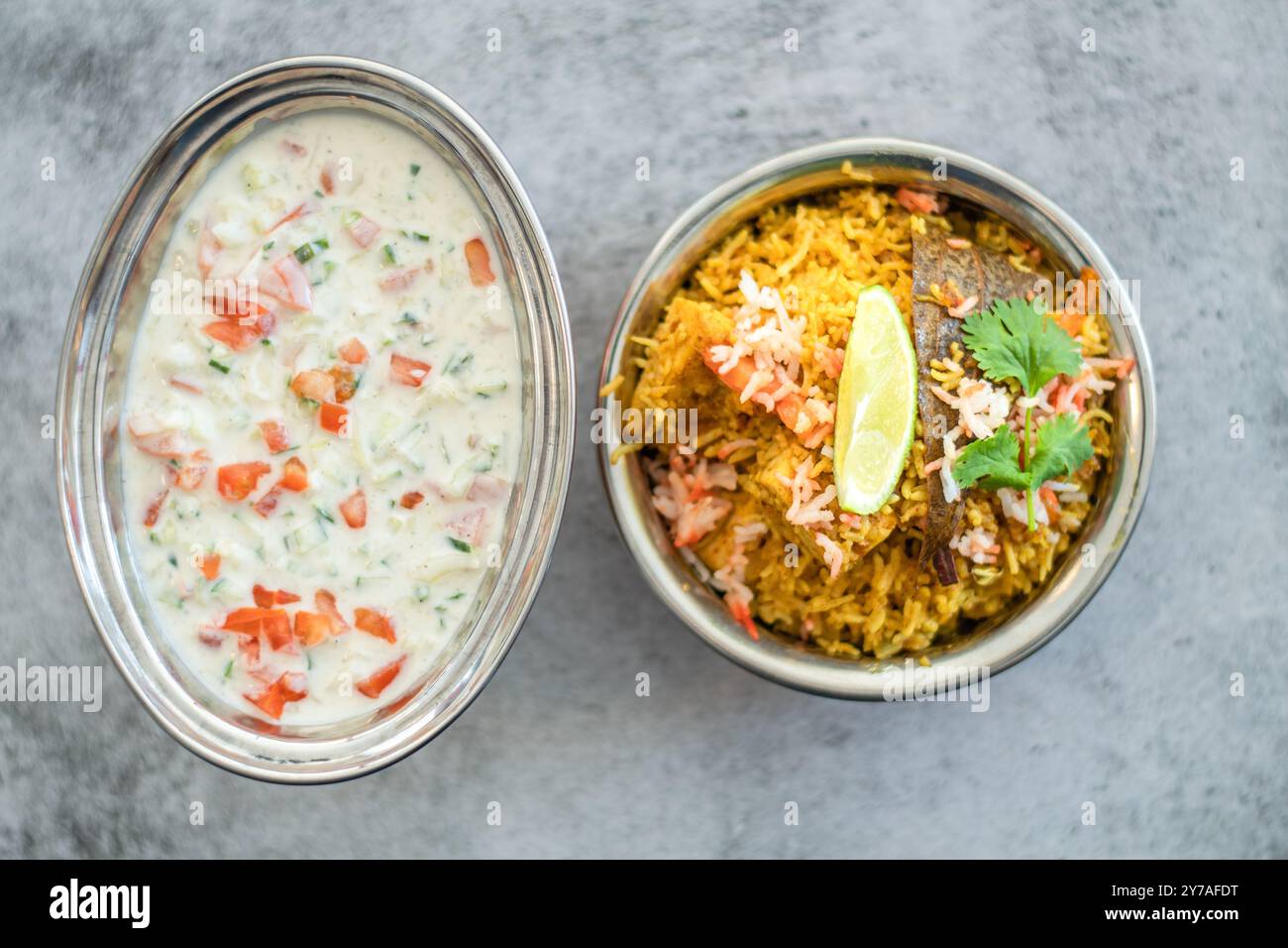 Würziger indischer Biryani-Pulao in goldener Schüssel mit indischem Basmati-Reisgericht mit Hühnerfleisch-Curry Ramadan Kareem, Eid. Servierschale aus Messing mit weißem Rücken Stockfoto