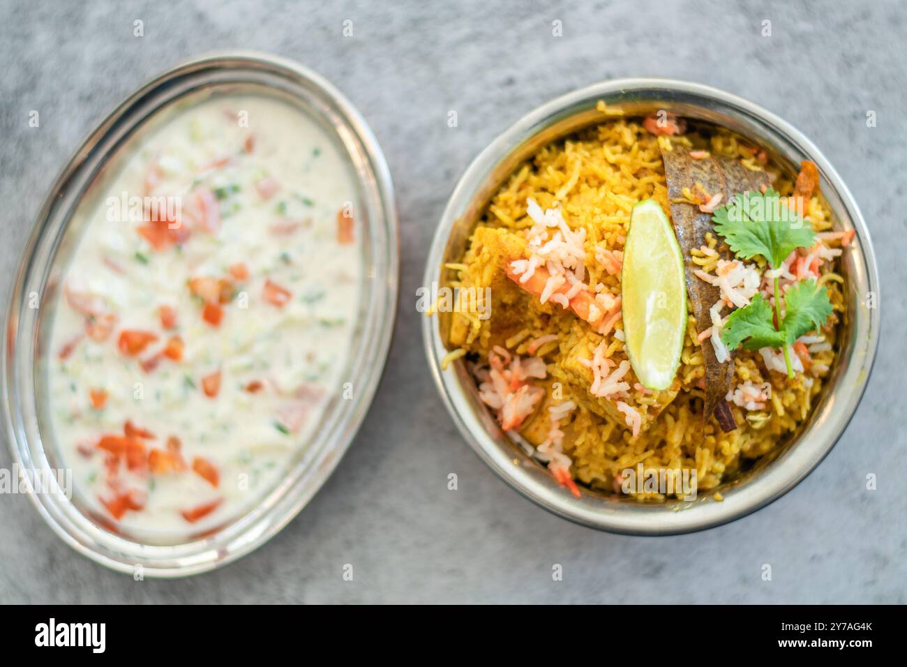 Würziger indischer Biryani-Pulao in goldener Schüssel mit indischem Basmati-Reisgericht mit Hühnerfleisch-Curry Ramadan Kareem, Eid. Servierschale aus Messing mit weißem Rücken Stockfoto
