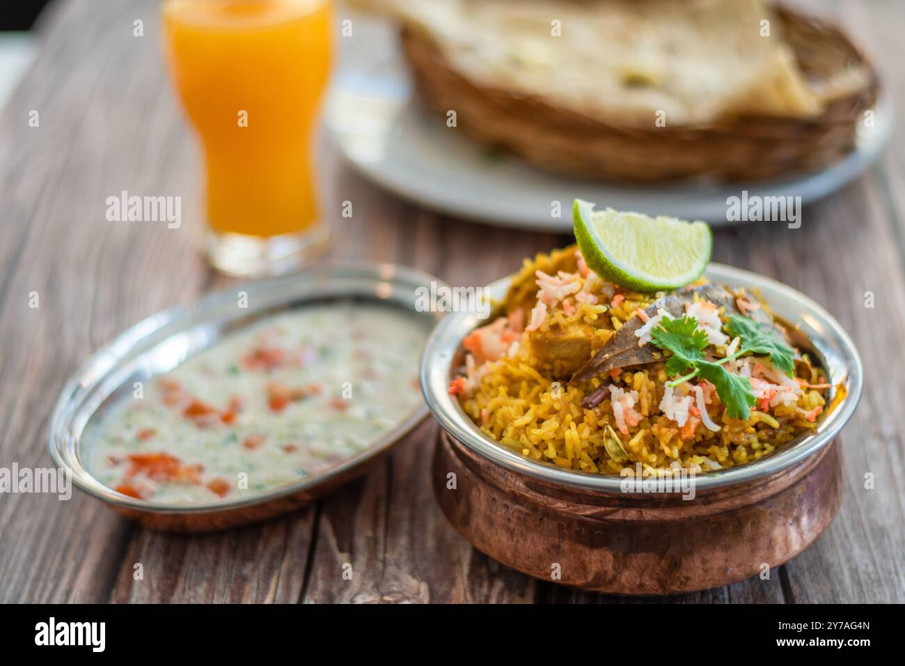 Würziger indischer Biryani-Pulao in goldener Schüssel mit indischem Basmati-Reisgericht mit Hühnerfleisch-Curry Ramadan Kareem, Eid. Servierschale aus Messing mit weißem Rücken Stockfoto
