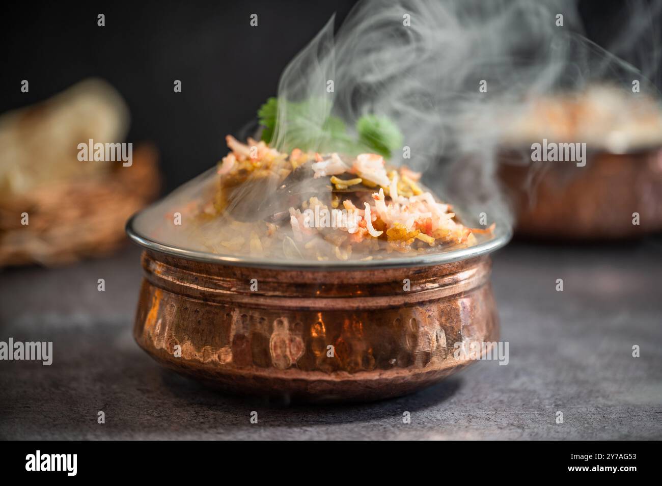 Rauchig scharfer indischer Biryani-Pulao in goldener Schüssel mit indischem Basmati-Reisgericht mit Hühnerfleisch-Curry Ramadan Kareem, Eid. Servierschüssel aus Messing mit Weißwein Stockfoto
