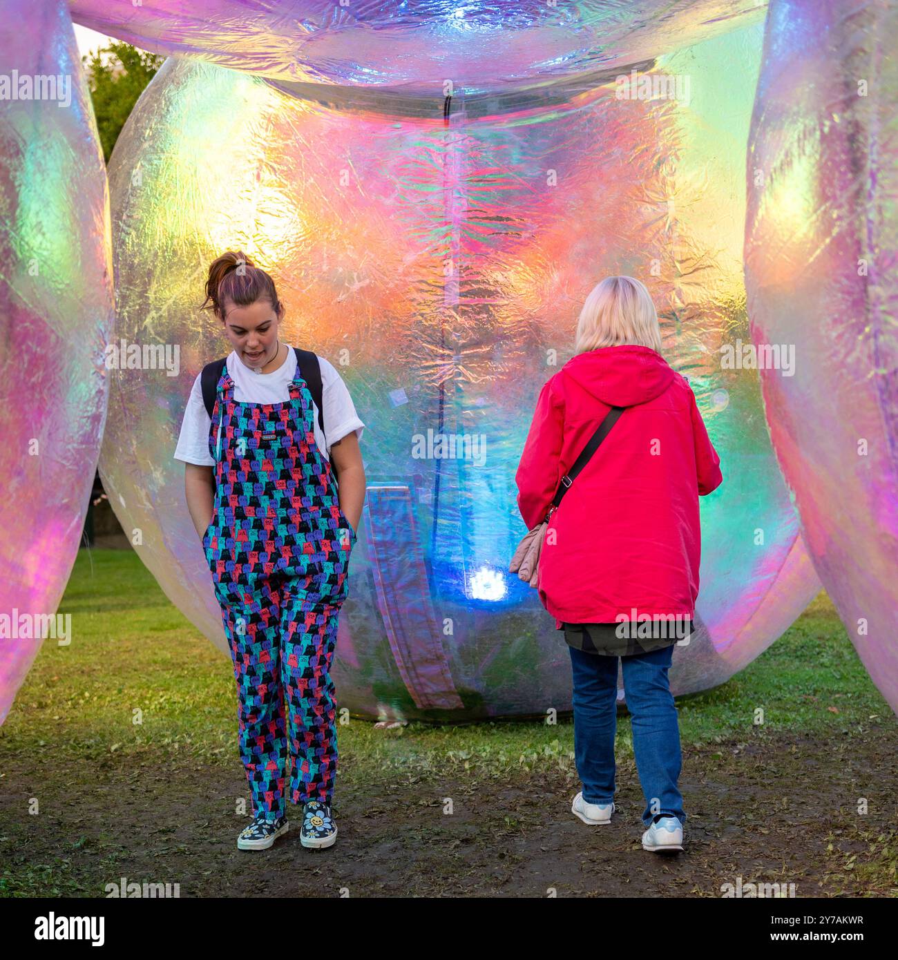 Bournemouth, Dorset, England, Vereinigtes Königreich, 28. September 2024. Arts by the Sea Festival. Zwei Frauen laufen unter einer riesigen Ballonstruktur Verwöhnend von Atelier Sisu. Quelle: Paul Biggins/Alamy Live News Stockfoto