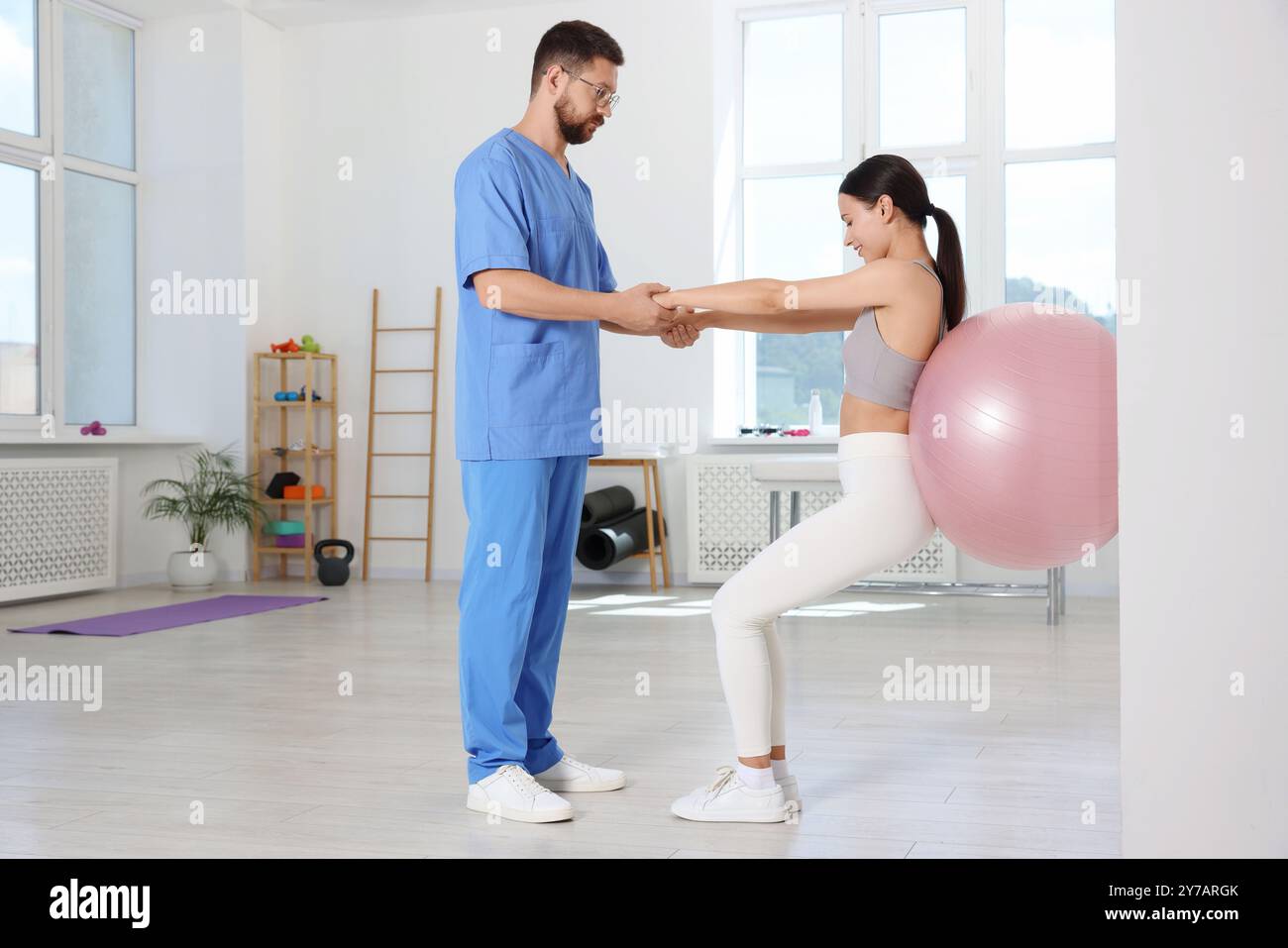 Physiotherapeut, der mit dem Patienten im Rehabilitationszentrum arbeitet Stockfoto