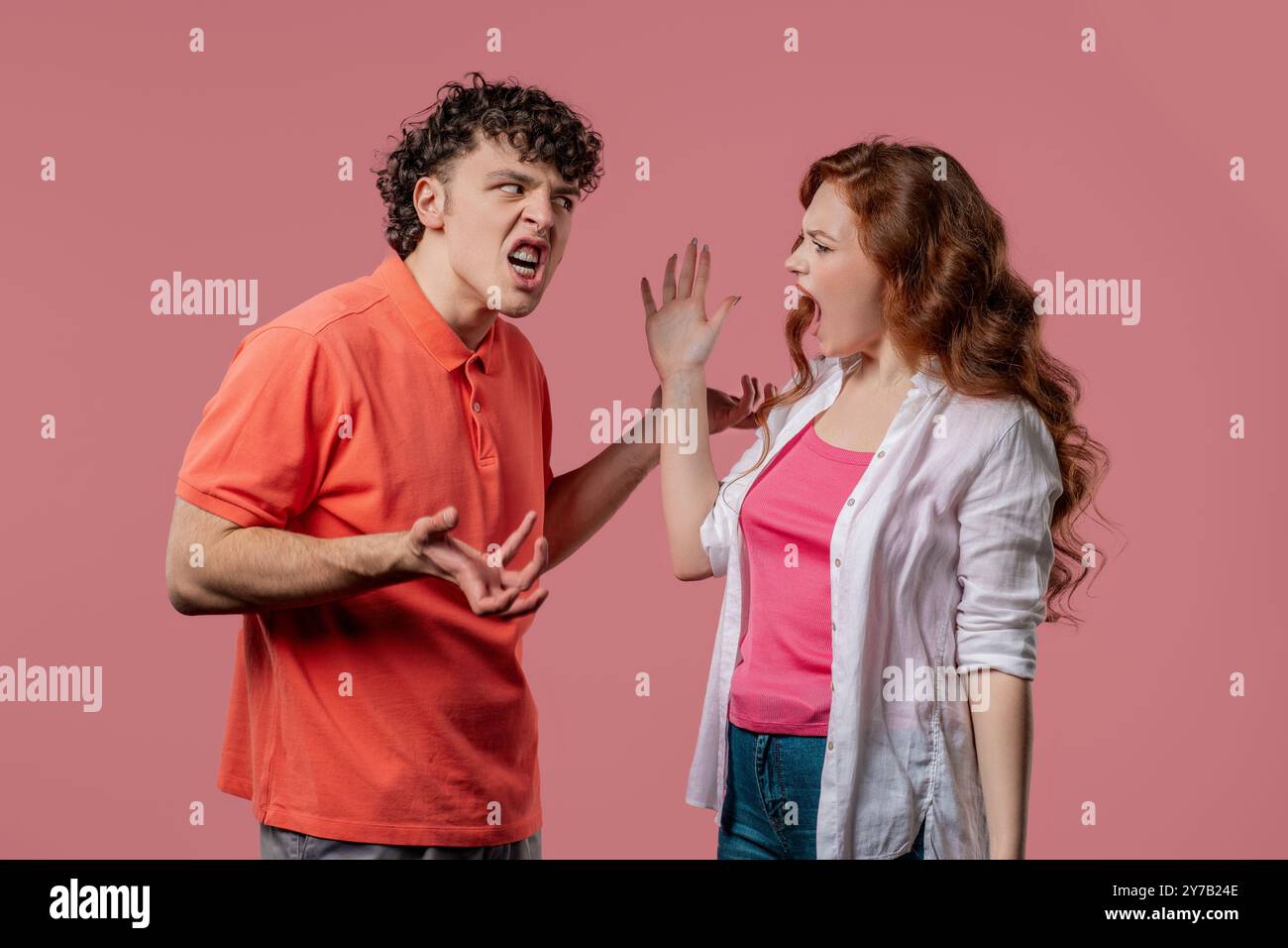 Das junge Paar streitet emotional auf rosa Hintergrund. Konfliktbegriff, Beziehungsprobleme. Weiße amerikanische Frau und Mann. Hohe Qualität Stockfoto