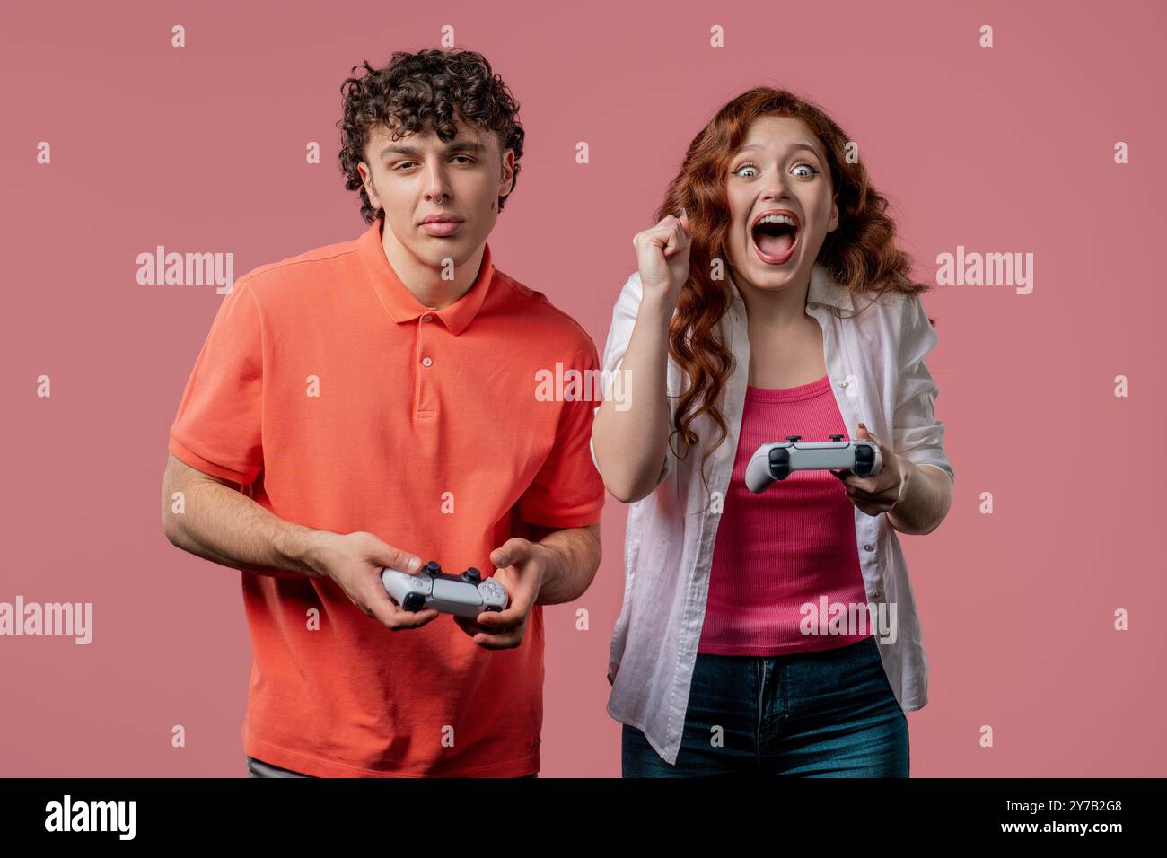 Das Paar des Spielers spielt Online-Videospiele mit Joysticks auf der Konsole, die Frau gewinnt. Drückt Tasten, mit Joypad-Controller, dem neuesten Wireless-Gamepad. Stockfoto