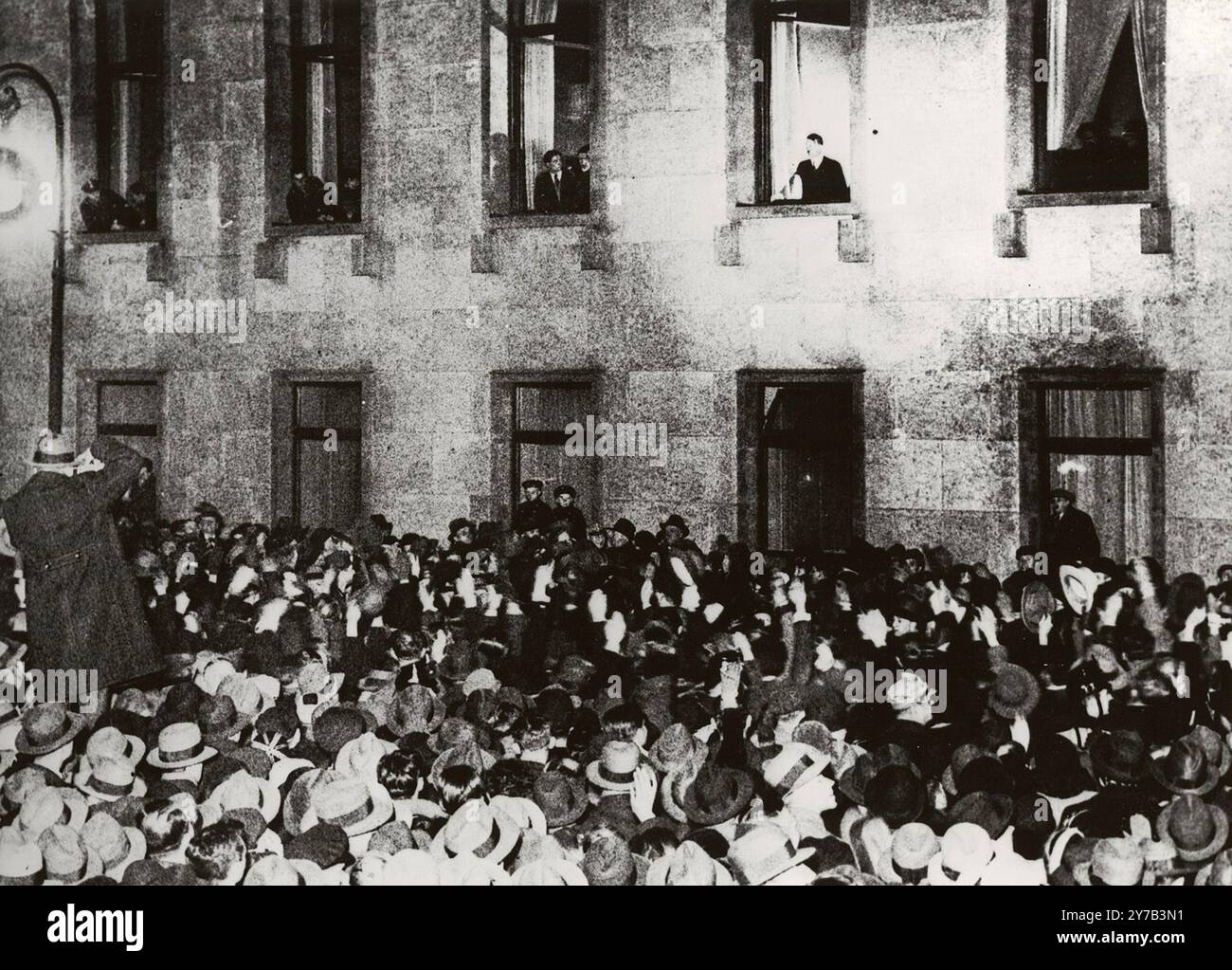 Adolf Hitler begrüßt die Teilnehmer einer Fackelparade am Abend seiner Ernennung zum Bundeskanzler. Das Datum, der 30. Januar 1933, markiert den Beginn der globalen Katastrophe, die 12 Jahre später mit der Atomzerstörung in Japan endete. Stockfoto