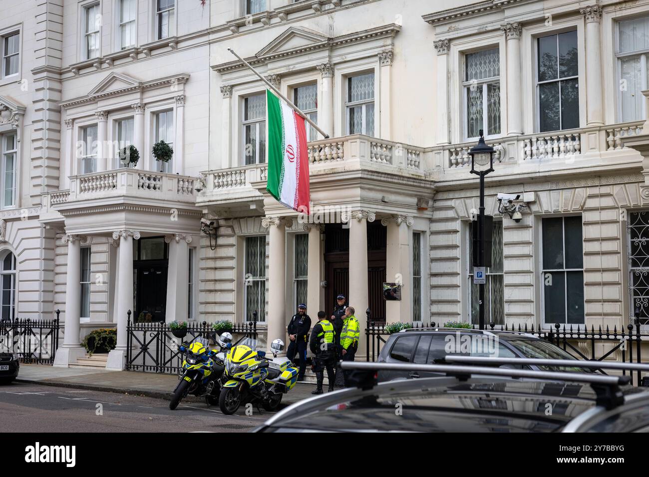 London, Großbritannien. September 2024. Die Flagge der Islamischen Republik Iran fliegt am Halbmast vor der iranischen Botschaft in London, als die Nation nach dem Tod von Hassan Nasrallah fünf Tage Trauer einnimmt. Die Metropolitan Police ist aus Sicherheitsgründen vor der Botschaft anwesend. Quelle: Sinai Noor/Alamy Live News Credit: Sinai Noor/Alamy Live News Stockfoto